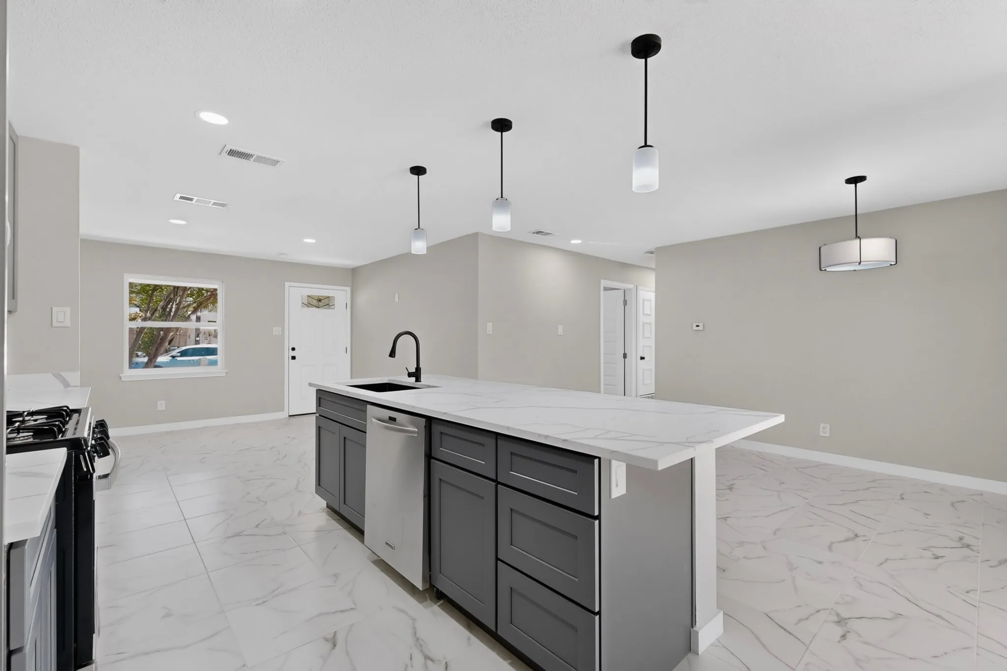 Kitchen island with stone-finish countertop, undermount sink, and matte black faucet