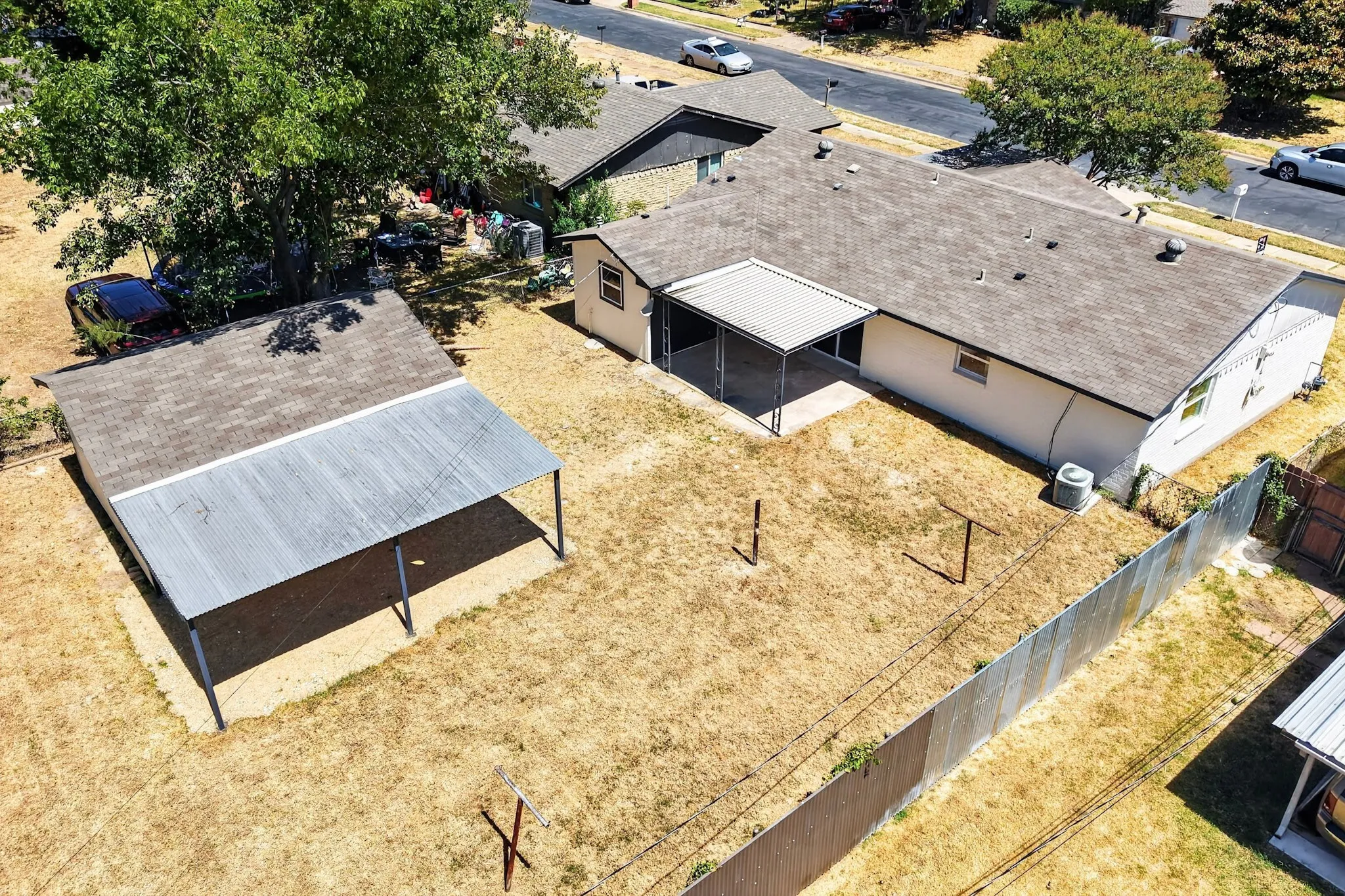 Spacious backyard with a detached shed featuring a covered carport