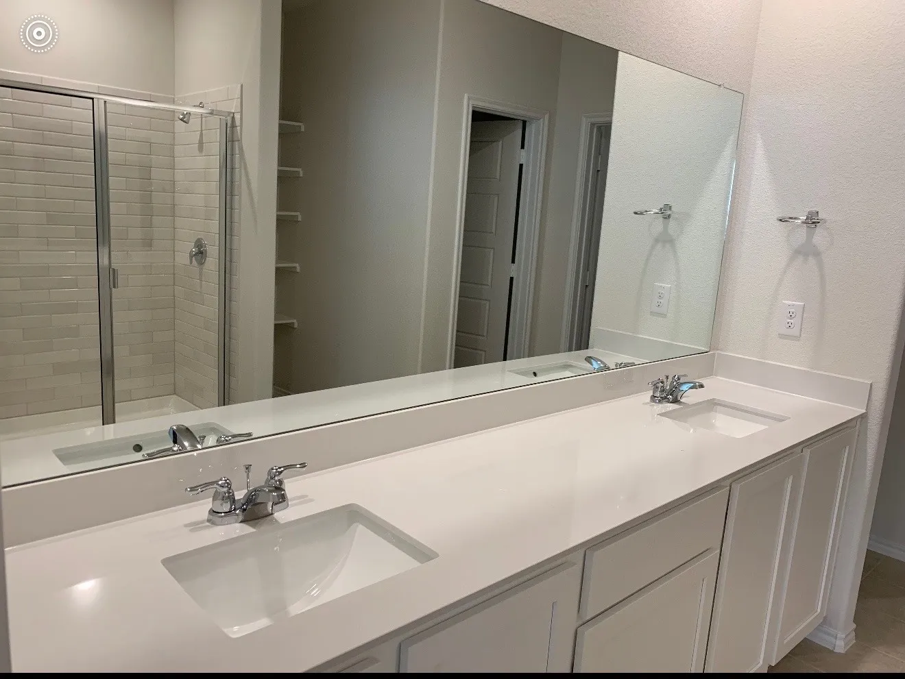 Dual vanity with integrated sinks, chrome faucets, and a full-width mirror