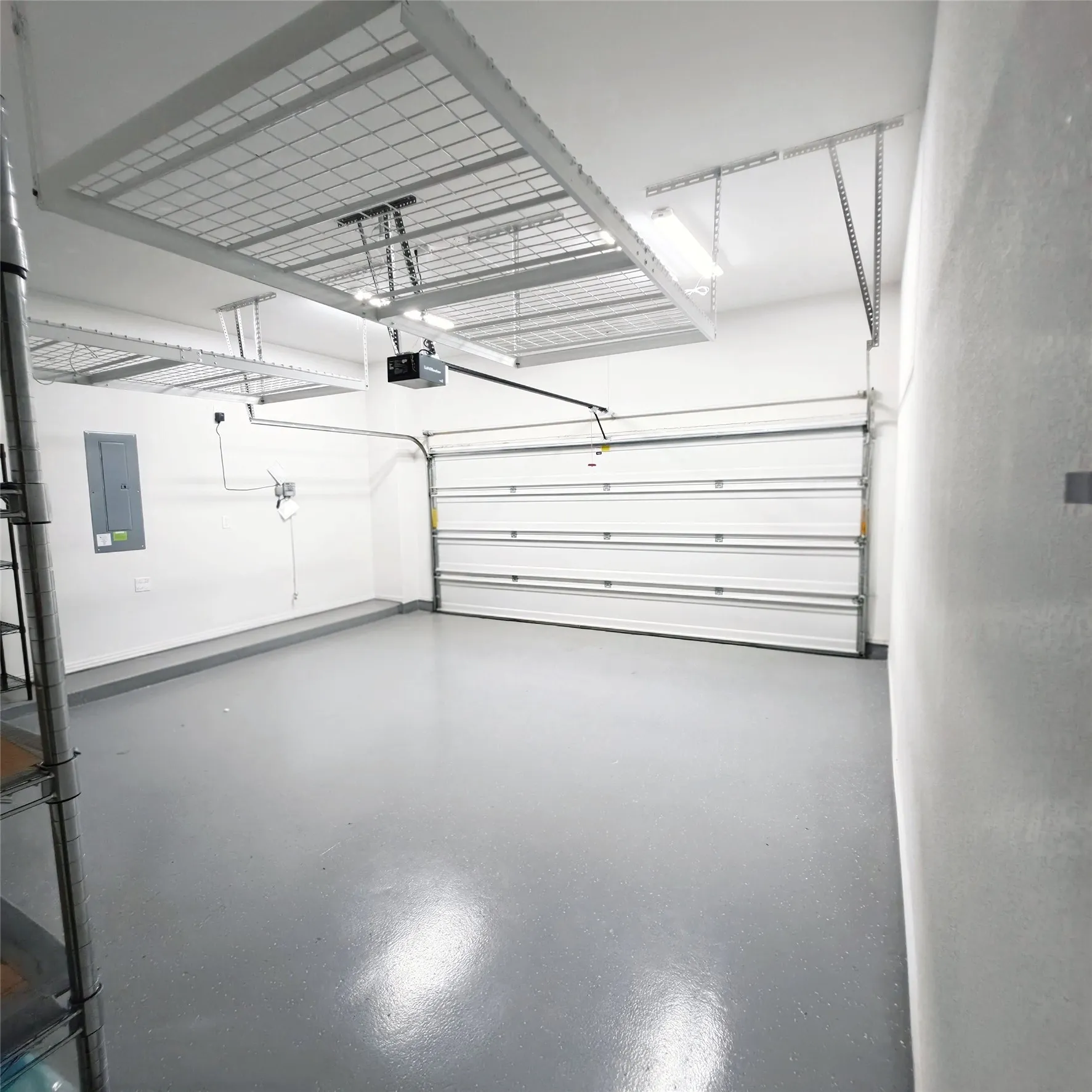 Garage featuring overhead storage racks and epoxy floor