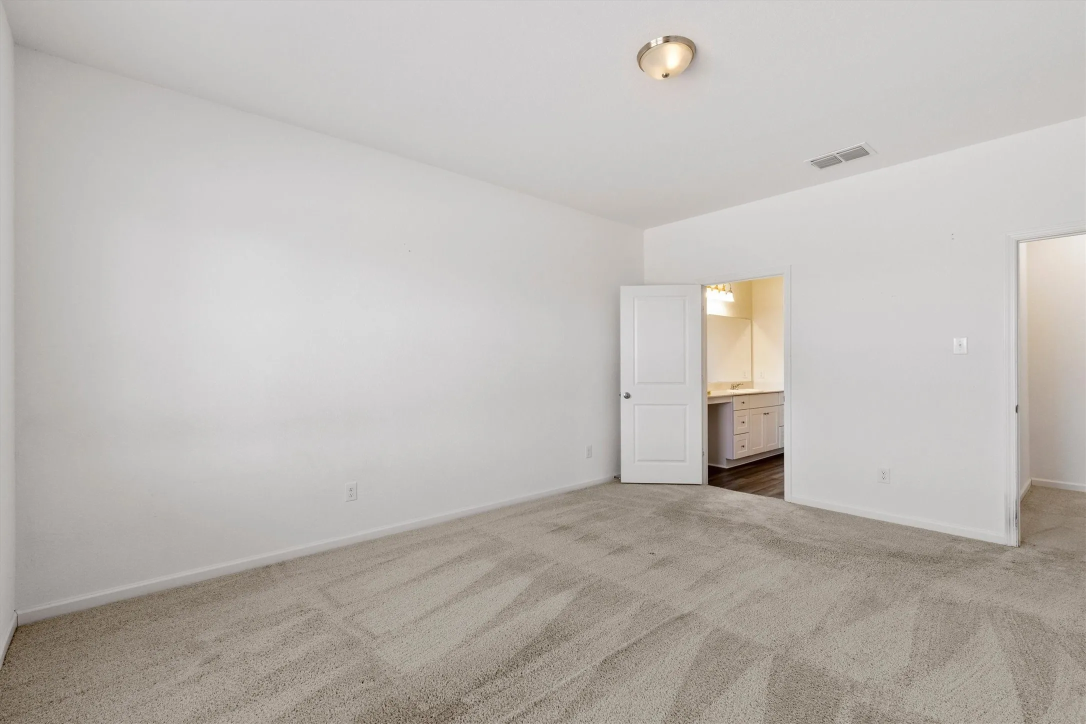 Large primary bedroom offering privacy in the back of the house with spacious ensuite bathroom.