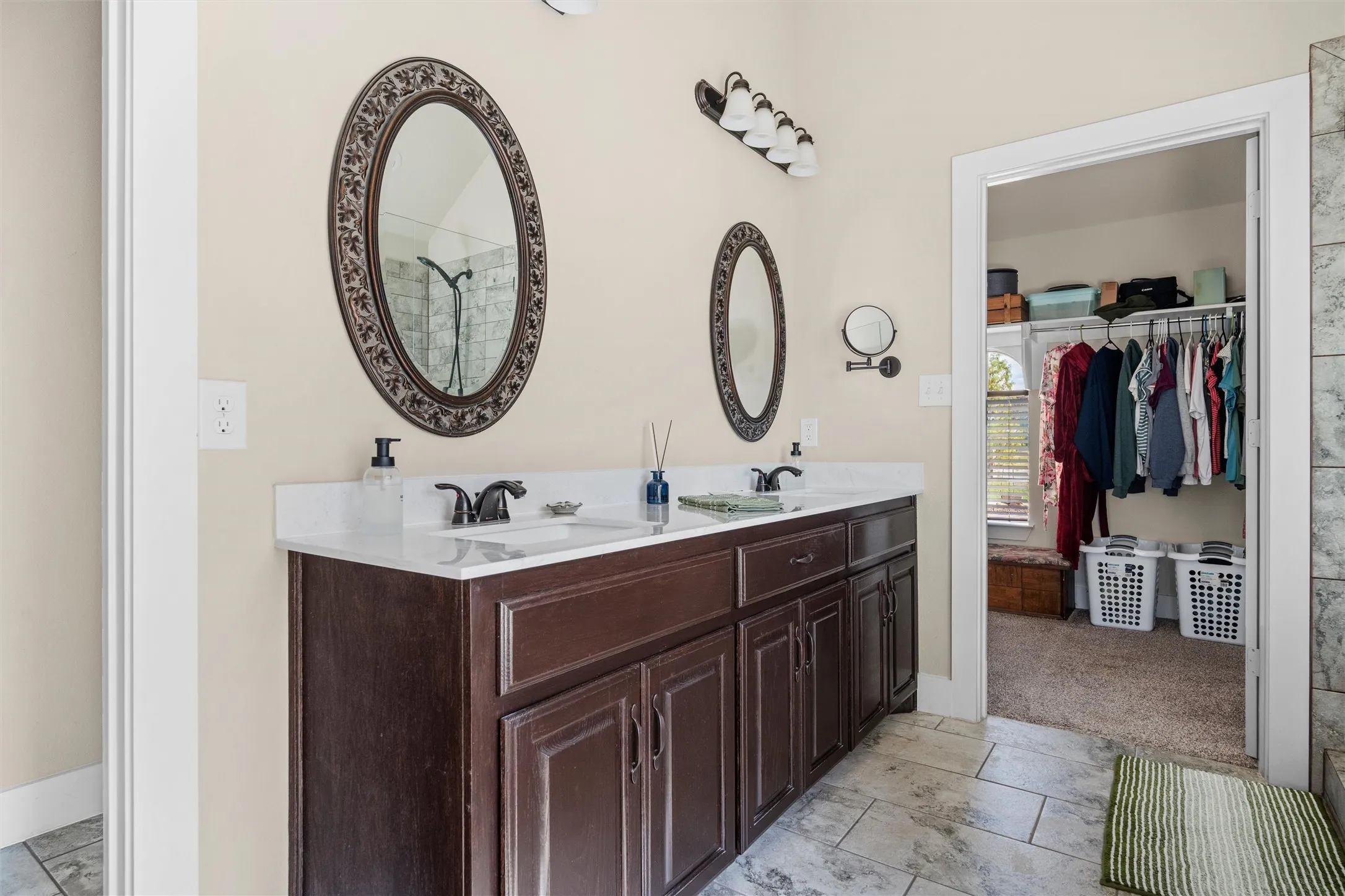 Double vanity with a white countertop and dark wood-finish cabinetry