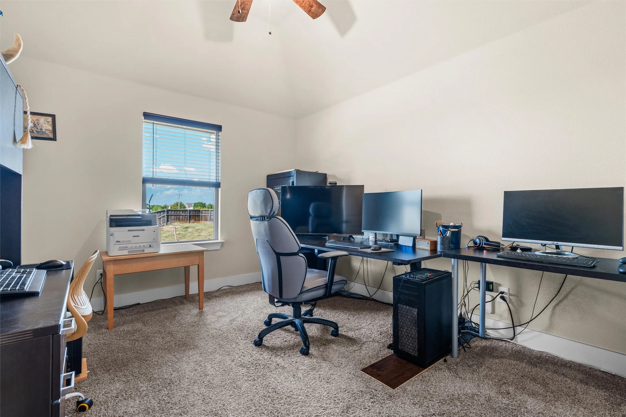 Carpeted room with a ceiling fan, a window with blinds, and neutral-toned walls