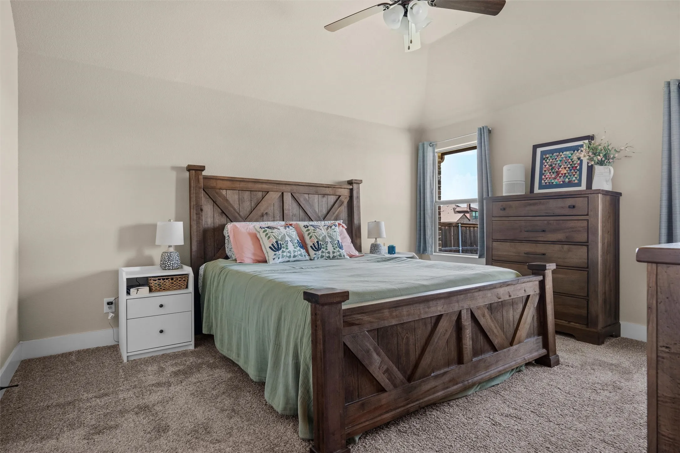 Vaulted ceiling with a ceiling fan, neutral wall tones, and carpeted flooring