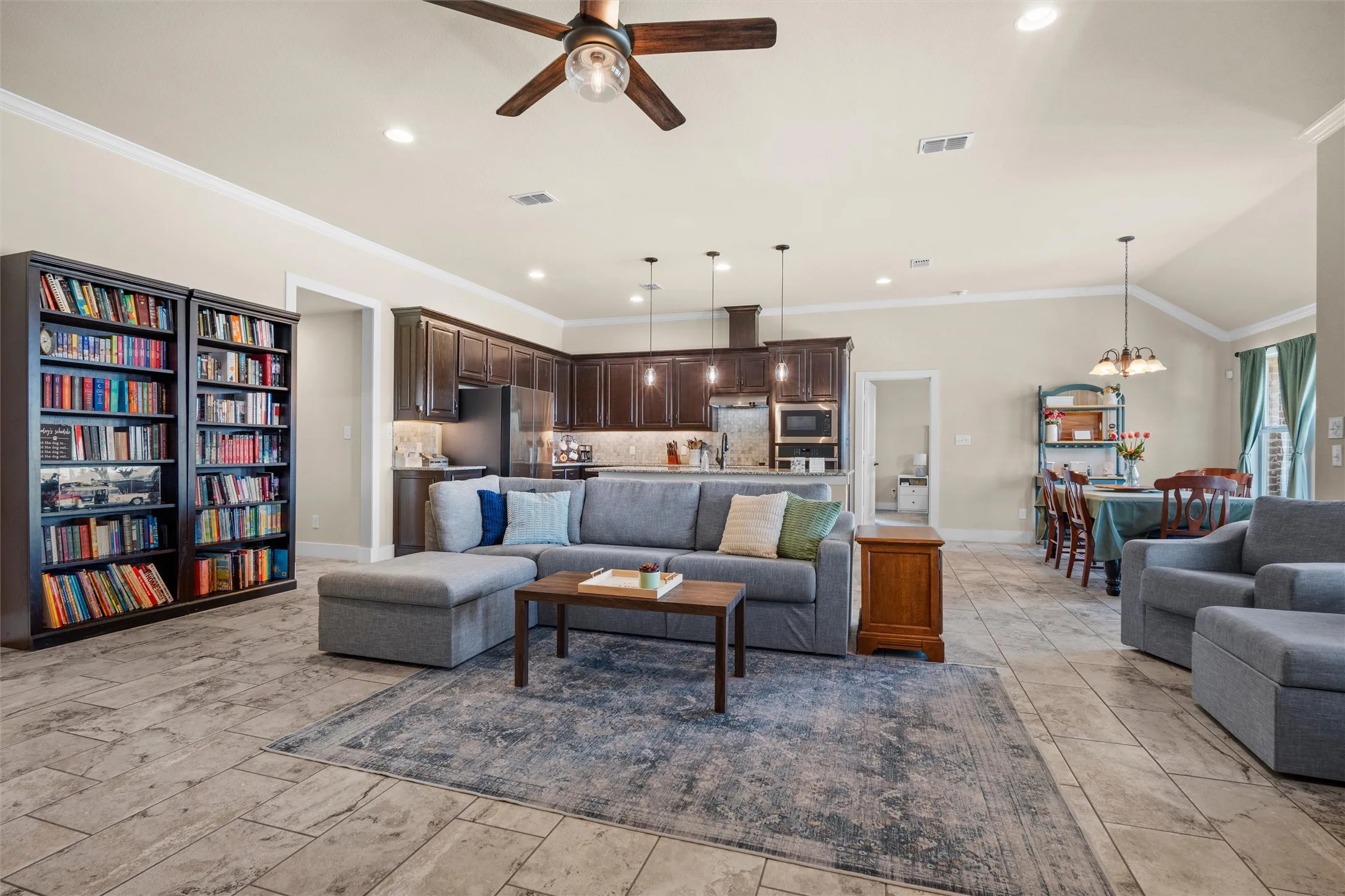 Open-concept living area featuring a wood-finish ceiling fan, recessed lighting, and tile flooring