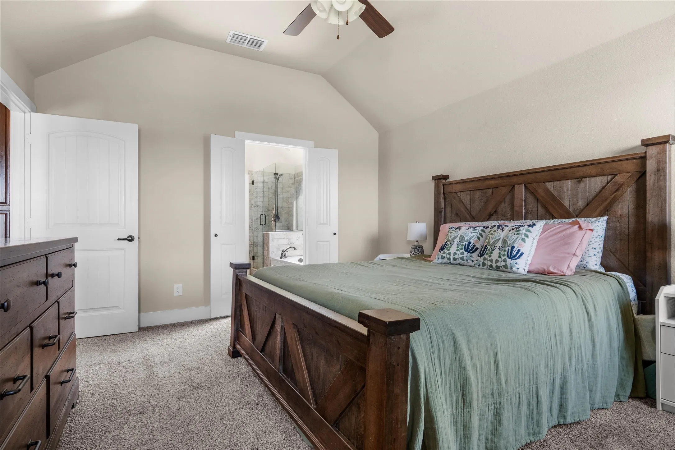 Vaulted ceiling with a ceiling fan, light-colored walls, carpeted flooring, and white paneled doors