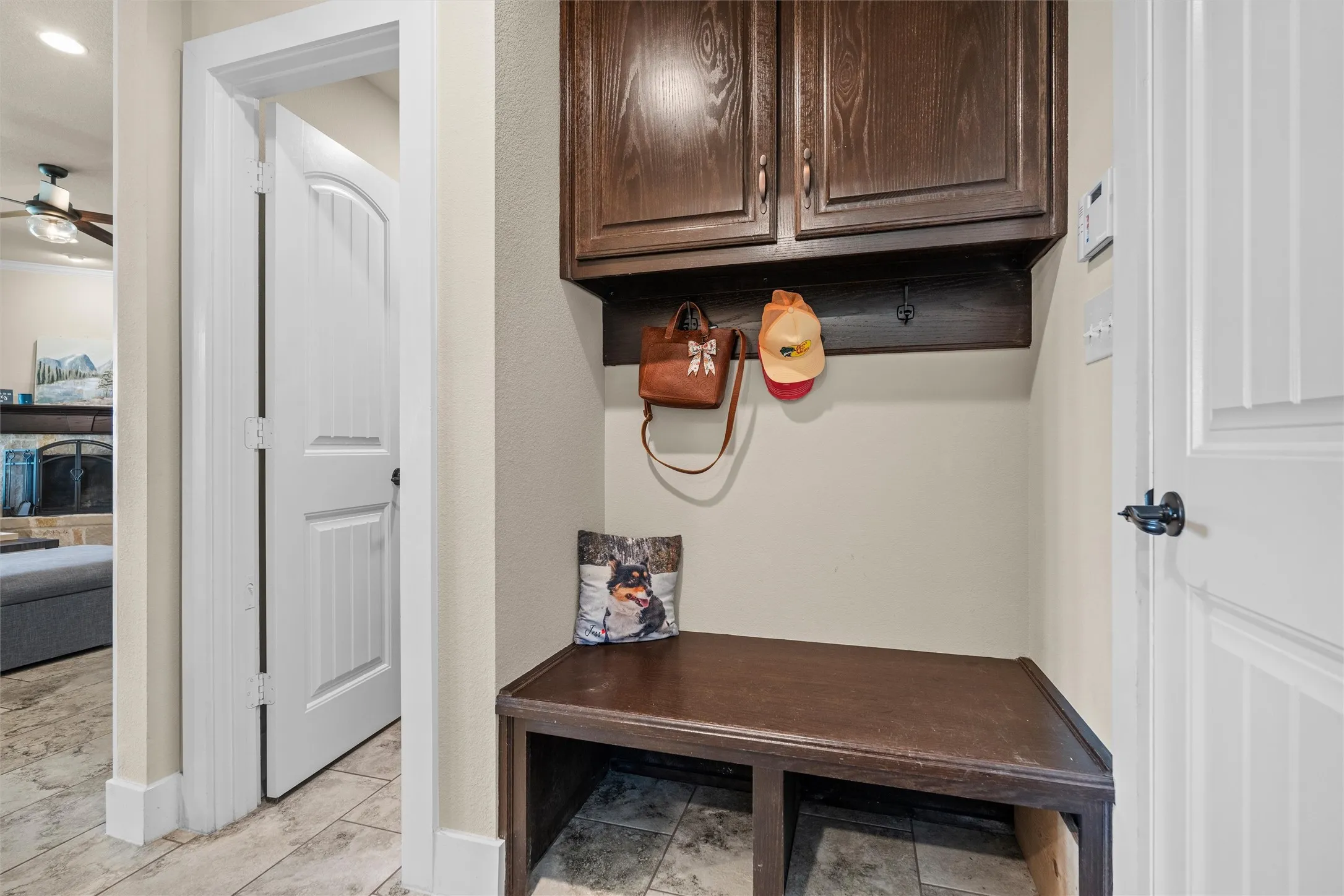 Built-in bench with dark wood-finish cabinetry and integrated coat hooks