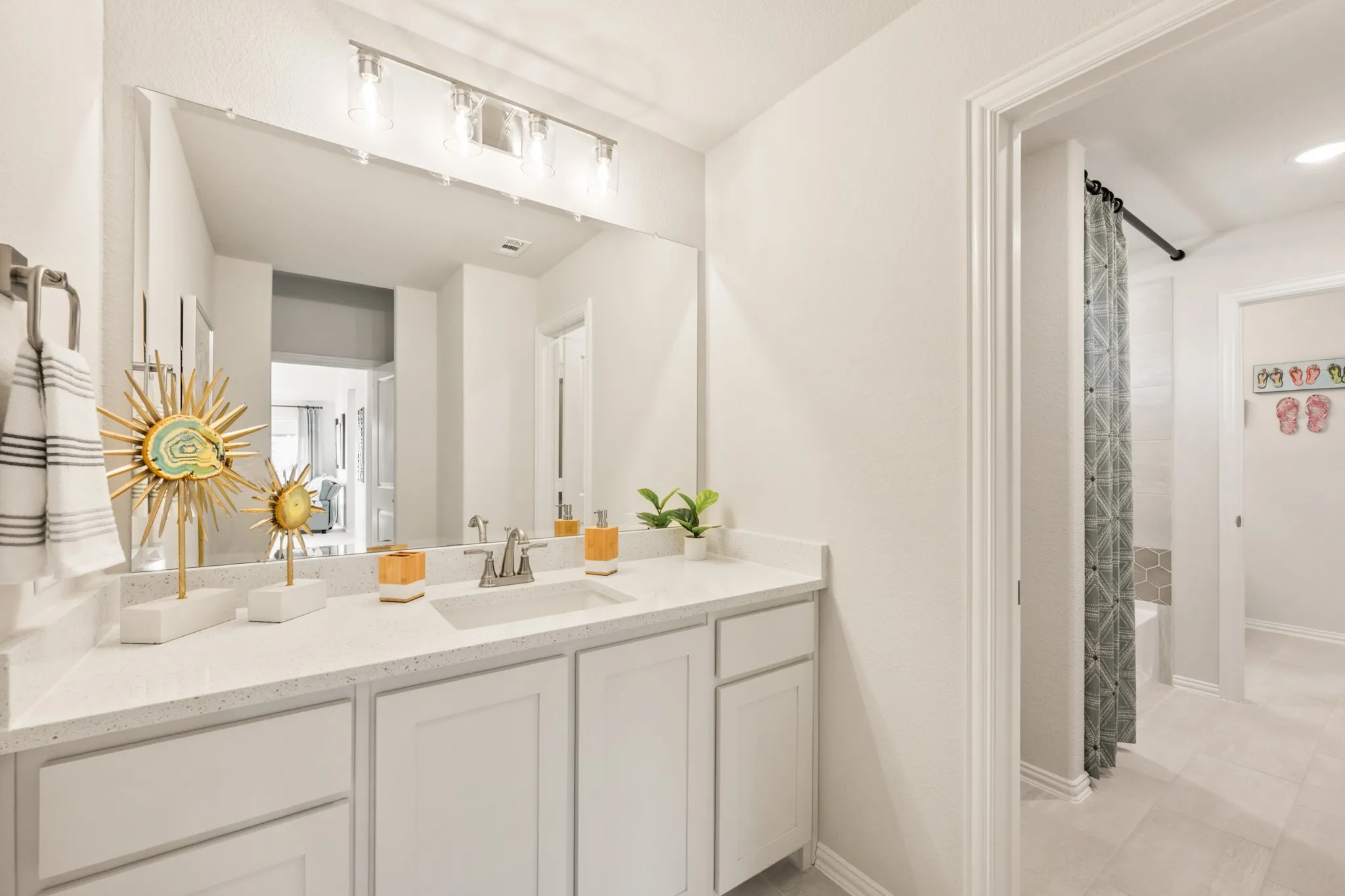 Double vanity with a white countertop and integrated sink, chrome faucet, and overhead lighting fixture