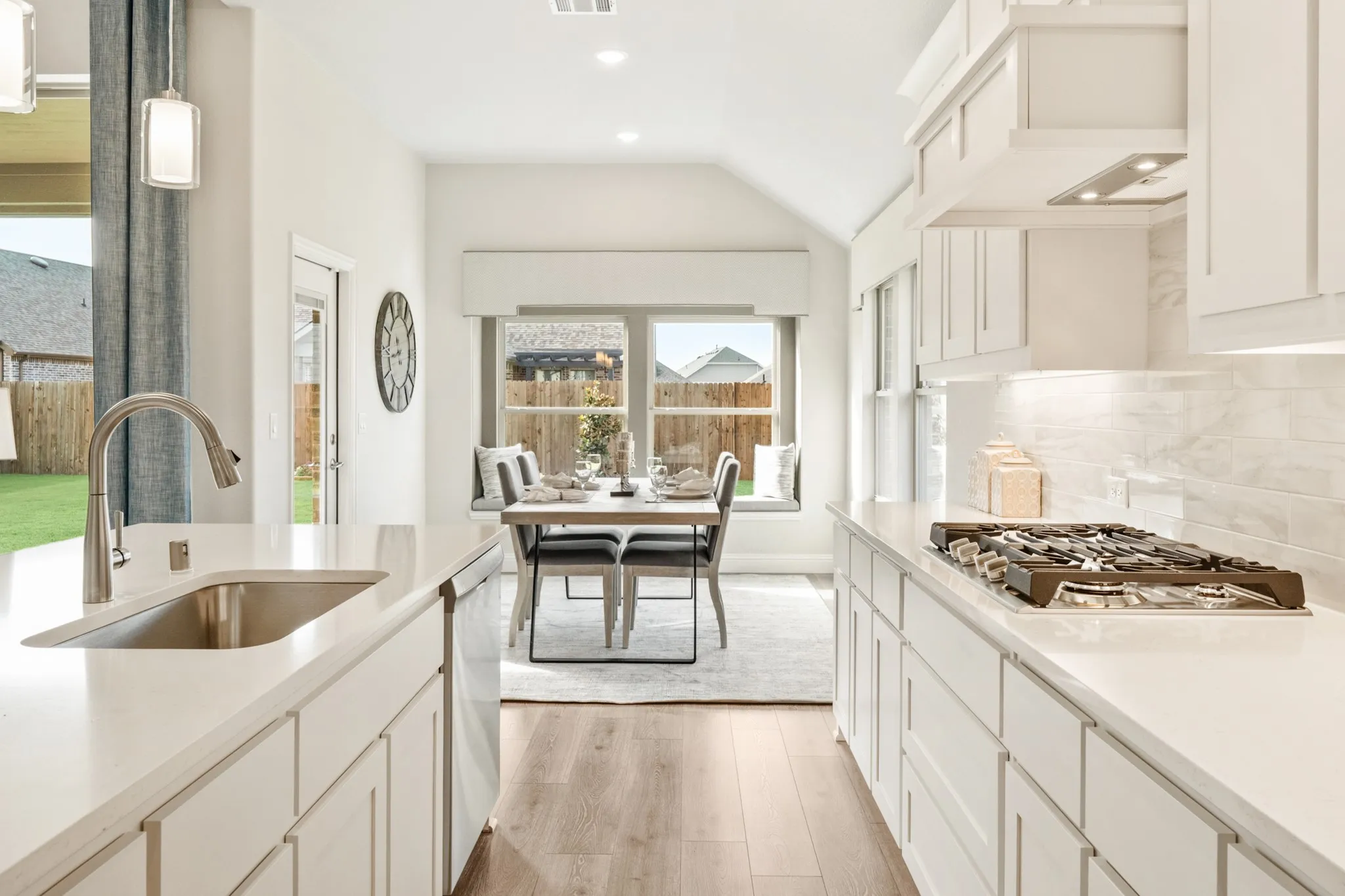 Kitchen featuring a gas cooktop, built-in dishwasher, stainless steel sink, under-cabinet lighting, and wood-finish flooring