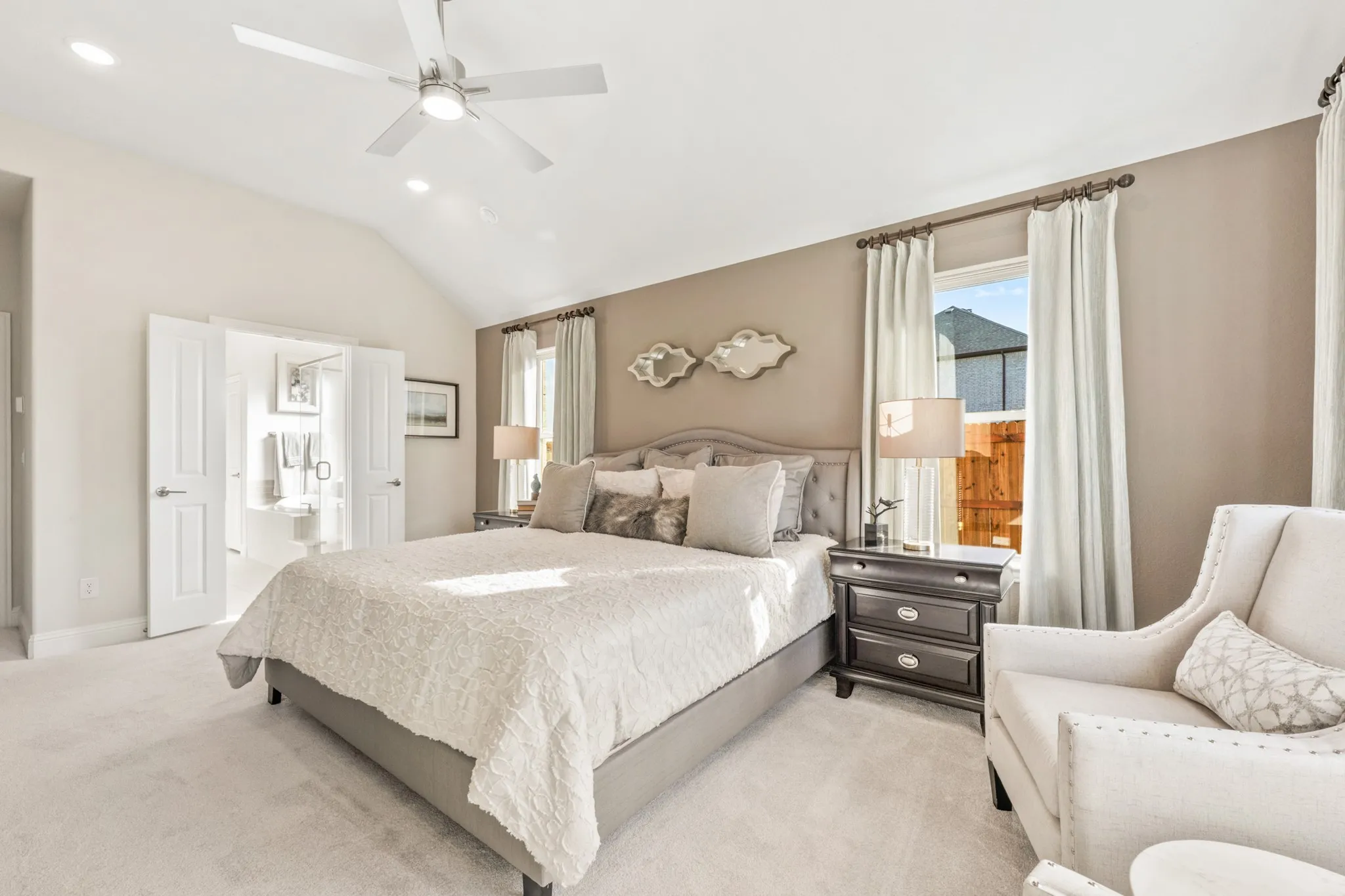 Vaulted ceiling with a ceiling fan, recessed lighting, carpet flooring, double French doors, and two windows with curtain rods