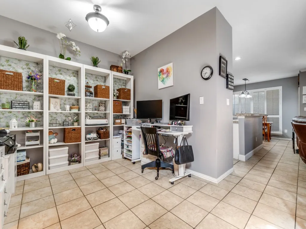 Neutral-toned tile flooring, built-in shelving, recessed lighting, and a partial wall defining distinct areas