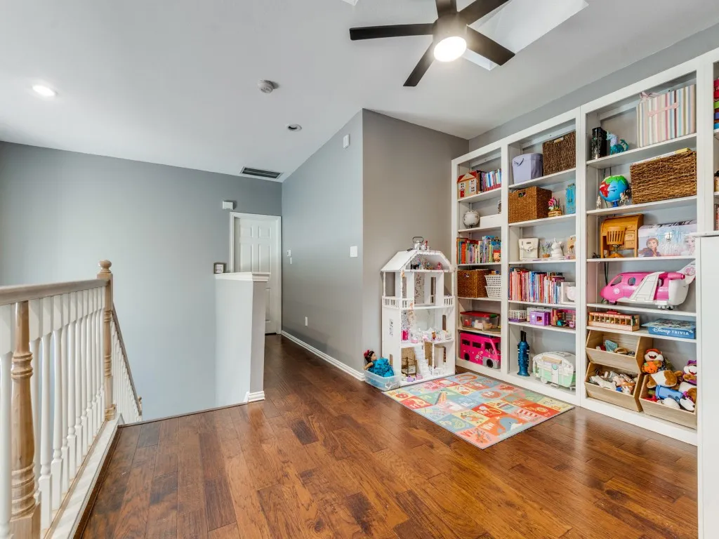 Hardwood-finish flooring, built-in shelving, ceiling fan with integrated lighting, recessed lighting, and a white paneled interior door