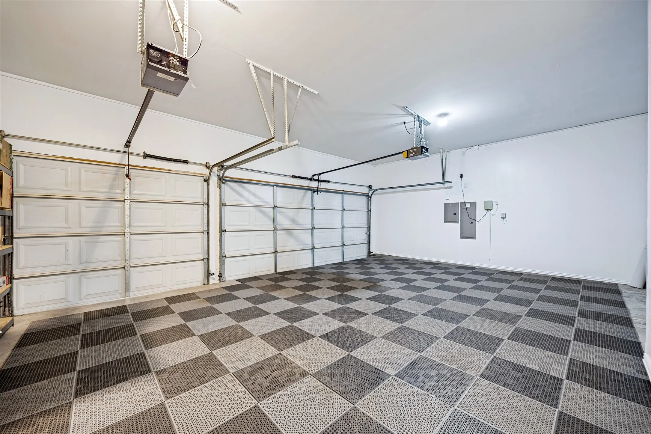 3-car garage featuring a checkerboard pattern floor and overhead lighting