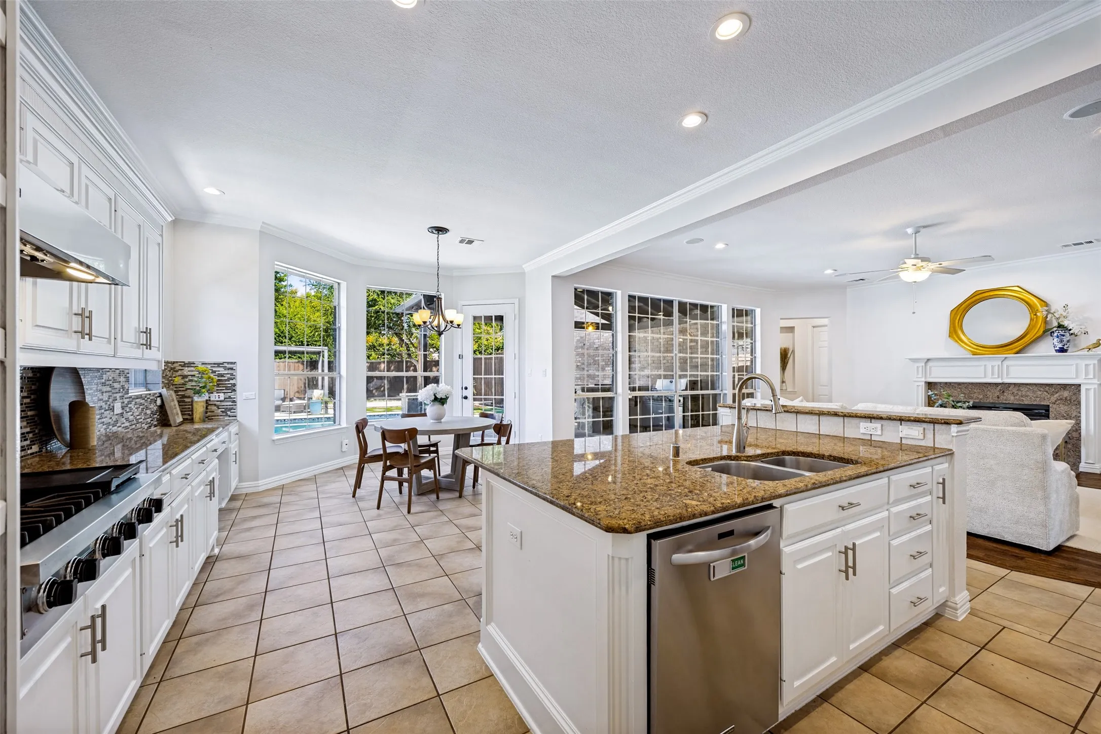 Kitchen featuring white cabinetry, granite countertops, stainless steel appliances, and tile flooring