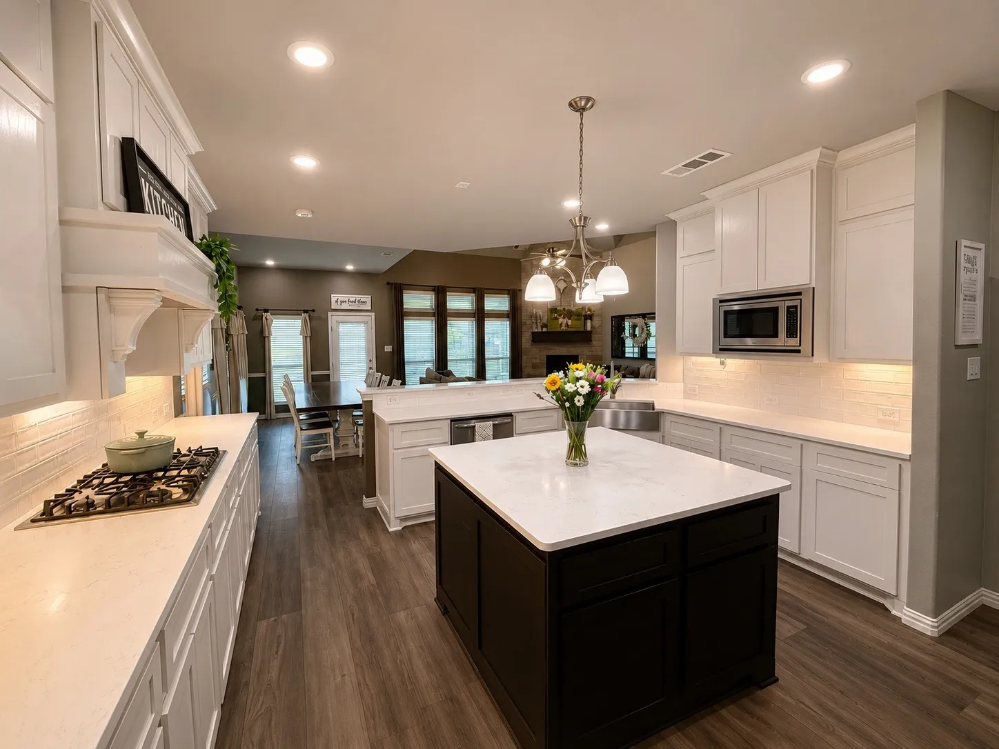 Kitchen with 4x4 island, double oven, gas stove top and stainless steel appliances. Hot water tap on kitchen sink, a walk in pantry and a butler's pantry.