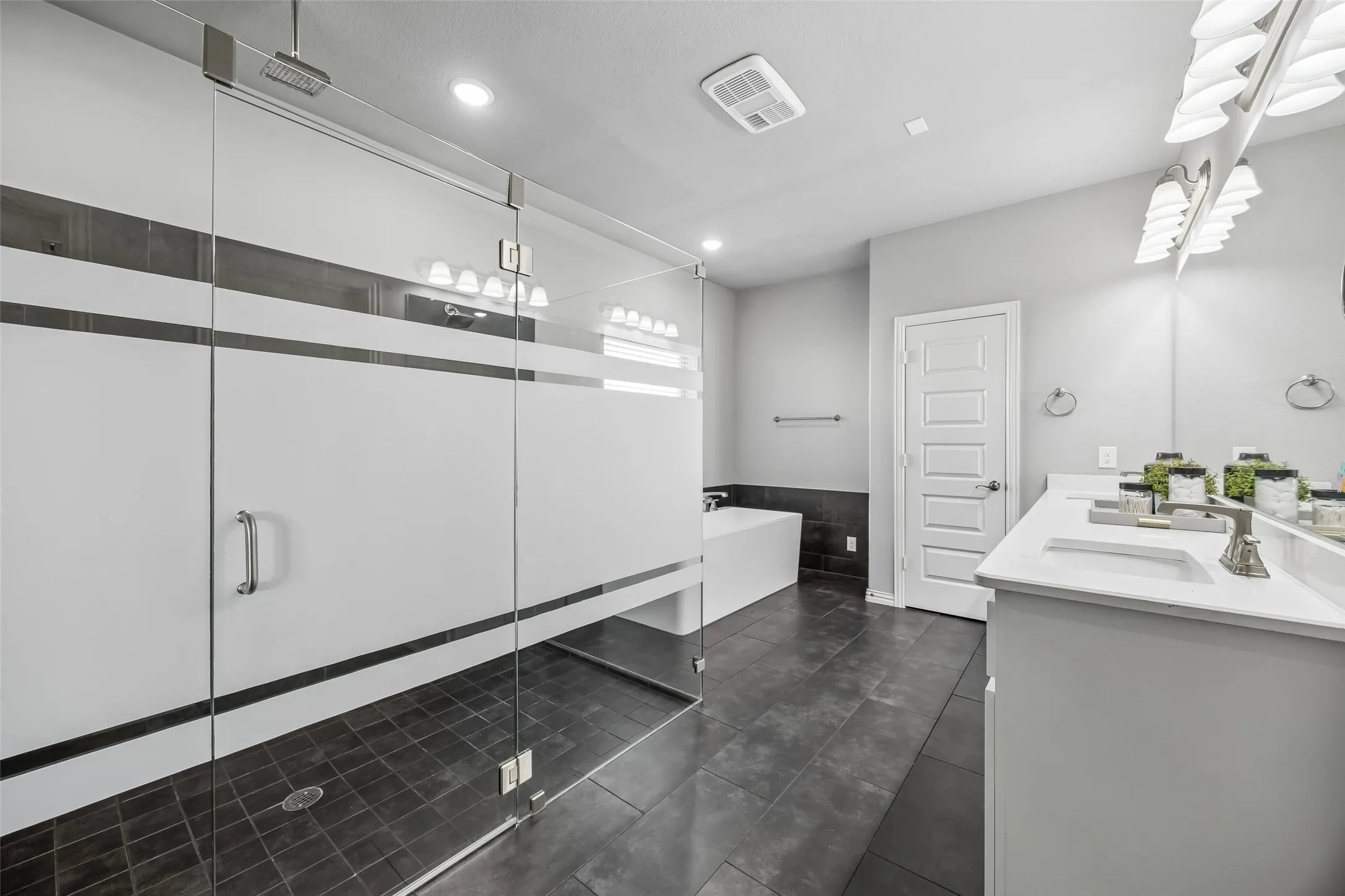 Primary bathroom with a double head shower and a rain shower, double sinks, soaking tub and quartz marble countertops.