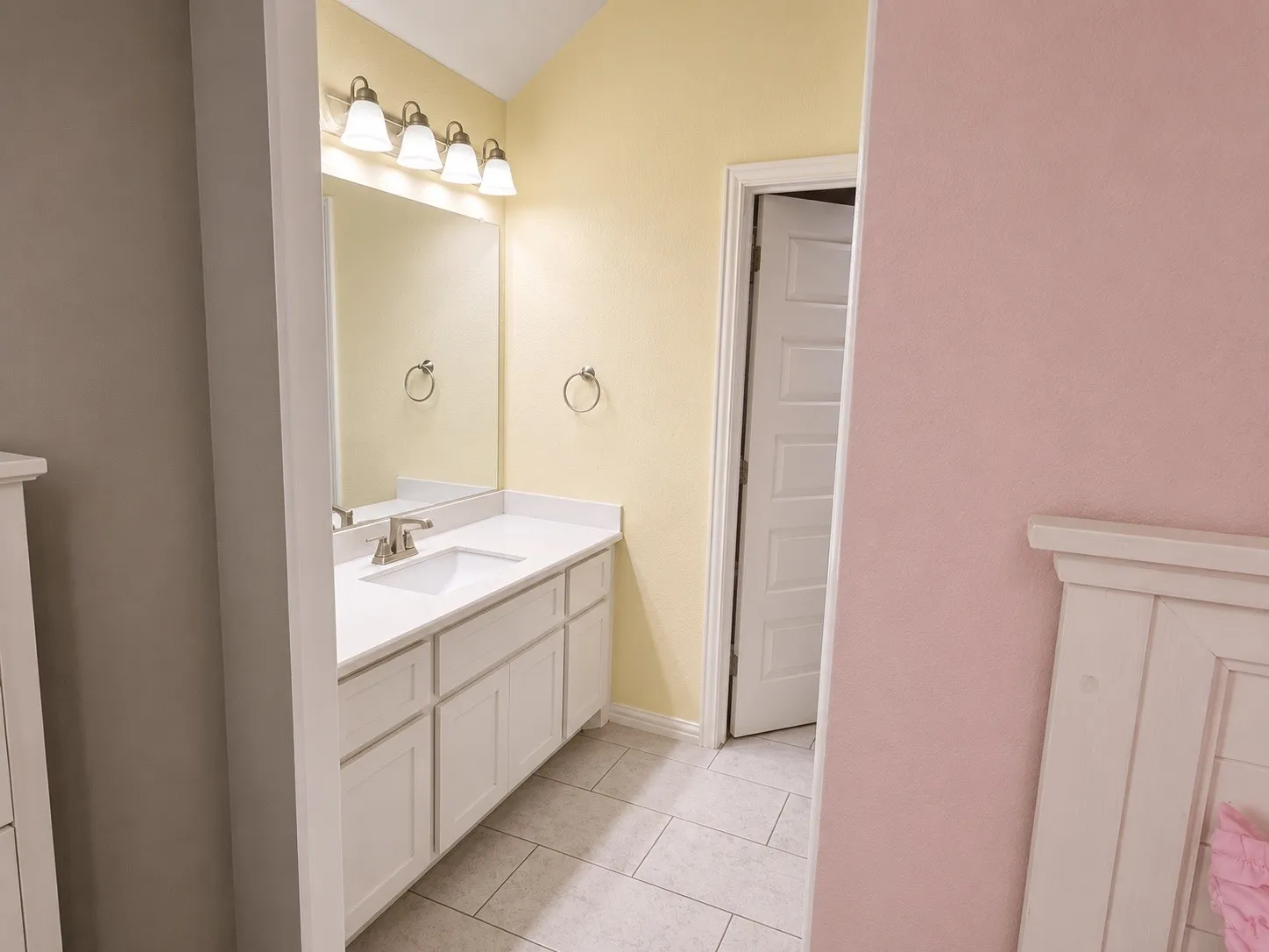 Jack and Jill bathroom from bedroom 4 - separate sink, cabinets, walk in closet with shared bathtub.
