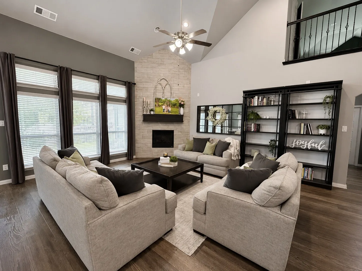 Living room with LVP flooring, natural light, gas fire place and tv hookups behind the mirror.
