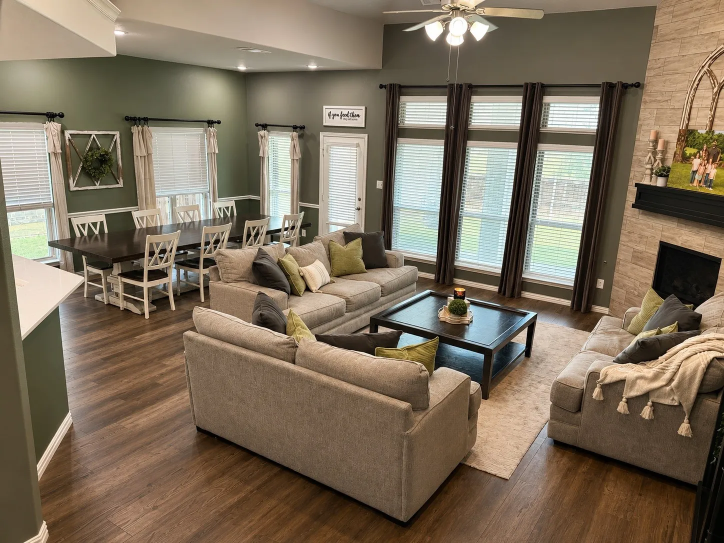 Living room with LVP flooring, natural light, gas fire place and tv hookups behind the mirror.