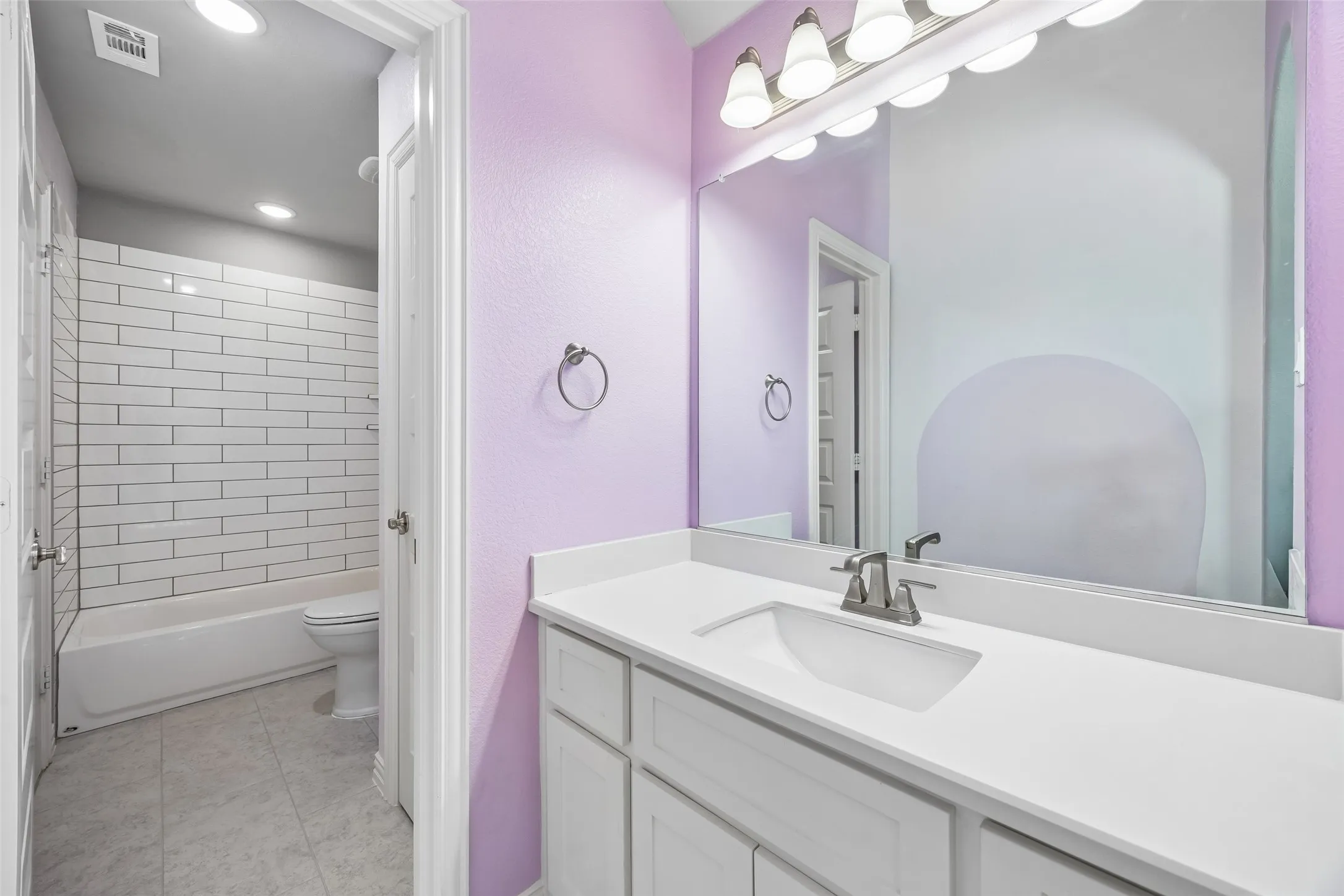 Jack and Jill bathroom from bedroom 3 - separate sink, cabinets with shared bathtub.