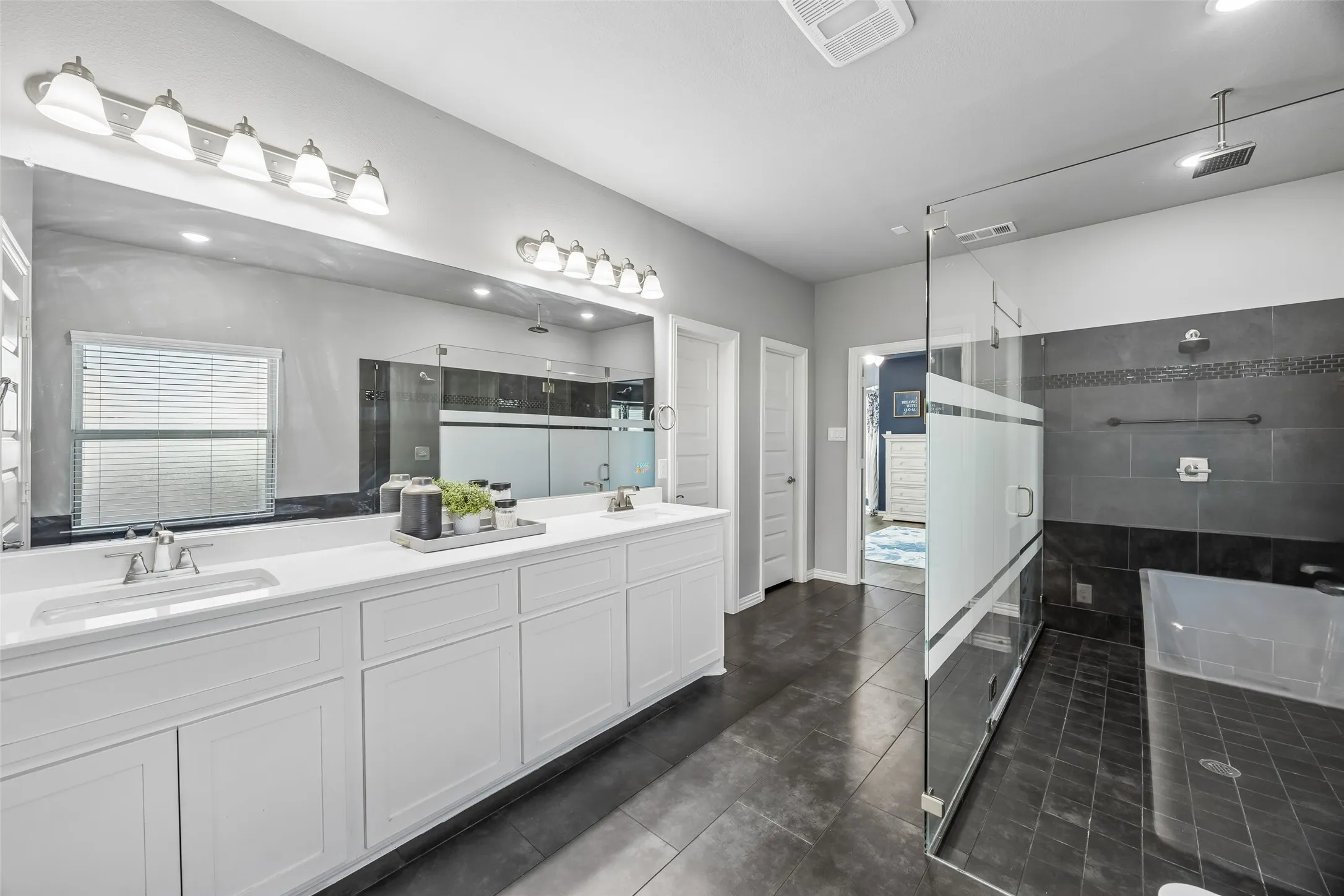 Primary bathroom with a double head shower and a rain shower, double sinks, soaking tub and quartz marble countertops.