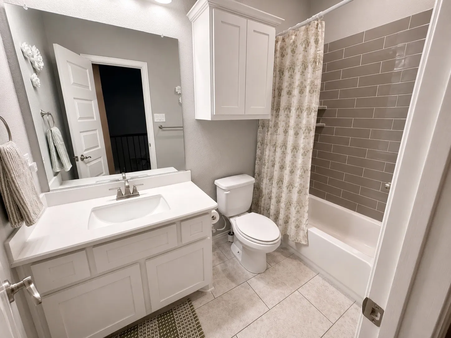 2nd Full size Bathroom upstairs with cabinets and tile.