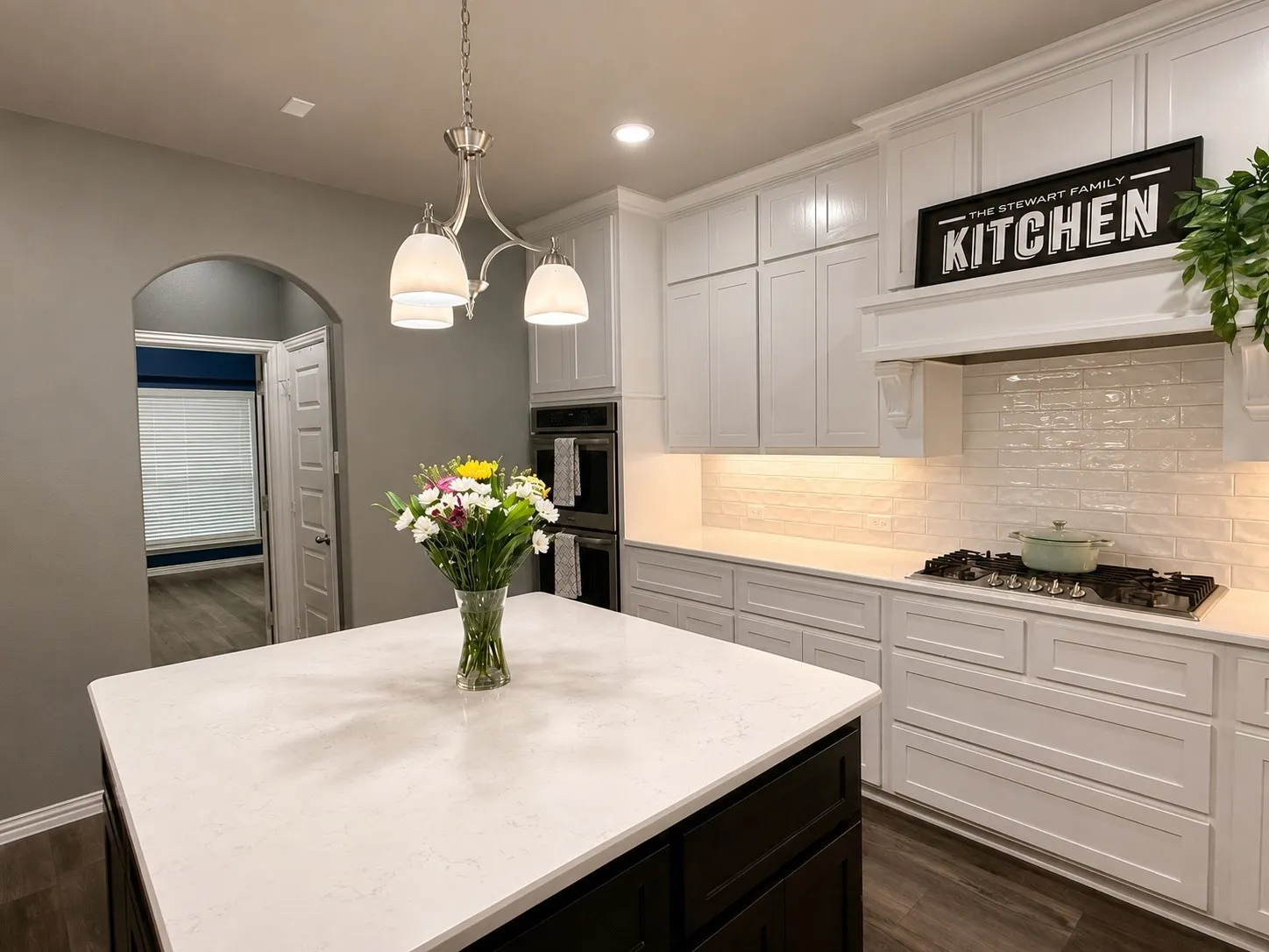 Kitchen with 4x4 island, double oven, gas stove top and stainless steel appliances. Hot water tap on kitchen sink, a walk in pantry and a butler's pantry.