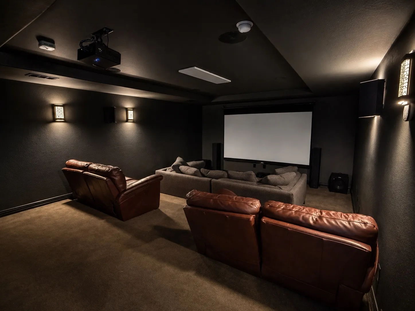 Media room with surround sound in the ceiling and movie theater lights.
