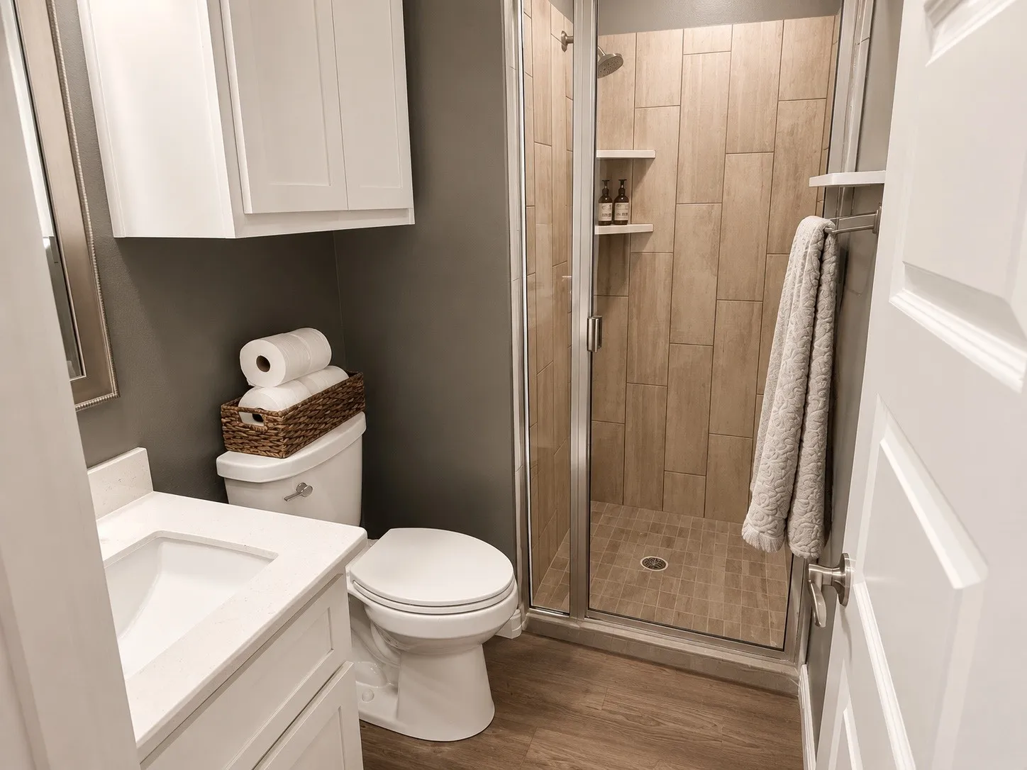 Full bathroom downstairs with sink, cabinets and a walk in shower.