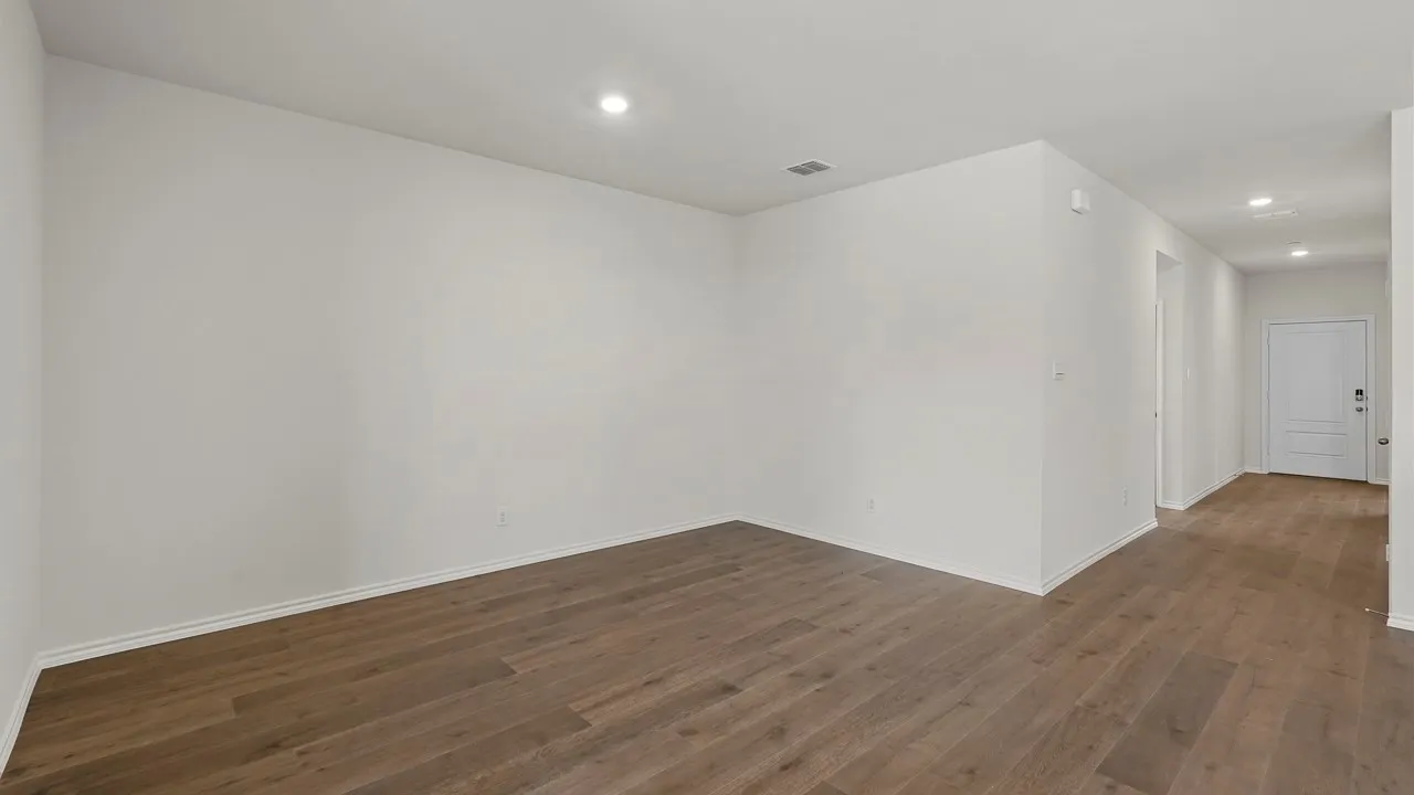 Recessed lighting, wood-finish flooring, and white walls throughout