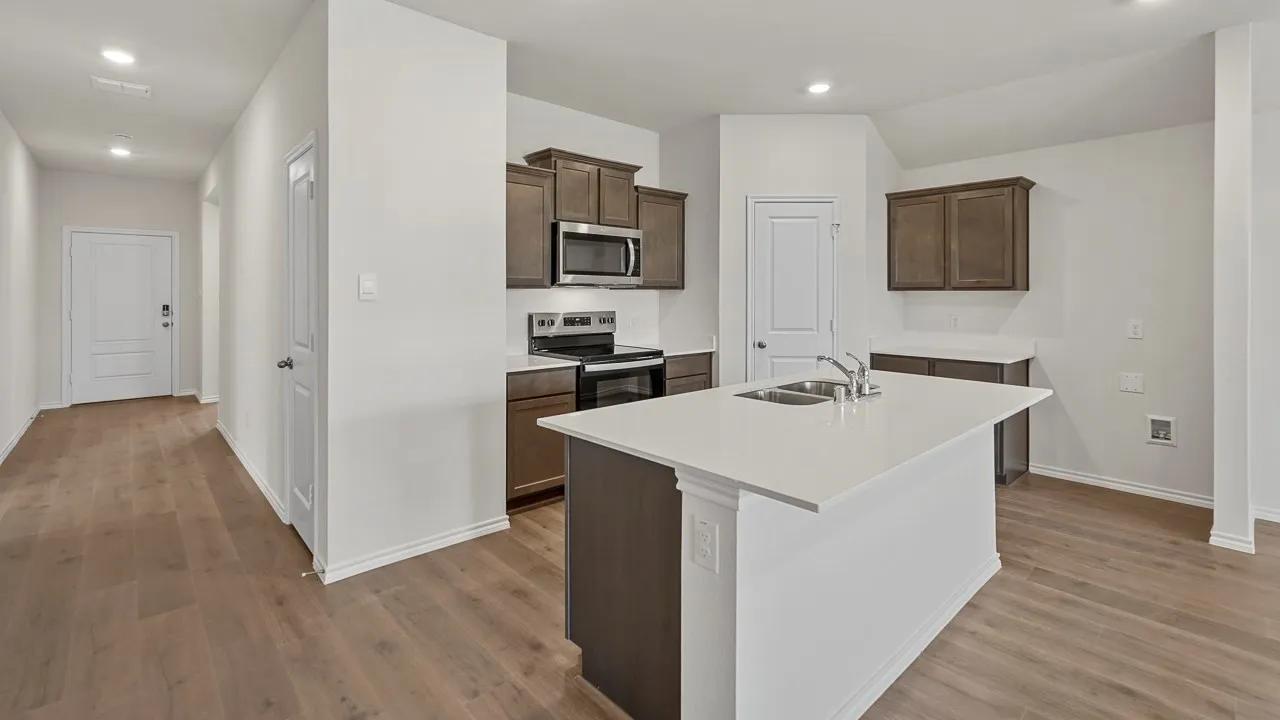 Kitchen featuring wood-finish flooring, recessed lighting, a kitchen island with an undermount sink, and stainless steel appliances