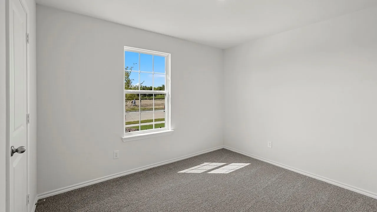 Neutral wall paint, carpet flooring, and a single window with white trim
