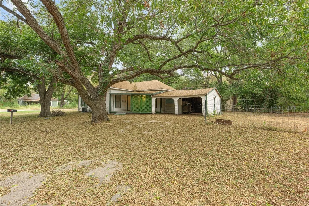 Mature trees providing shade, a covered carport, and a separate storage shed are features of this property