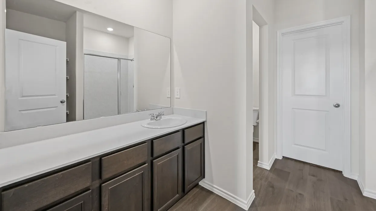 Extended vanity featuring a white countertop, undermount sink, and dark wood-finish cabinetry