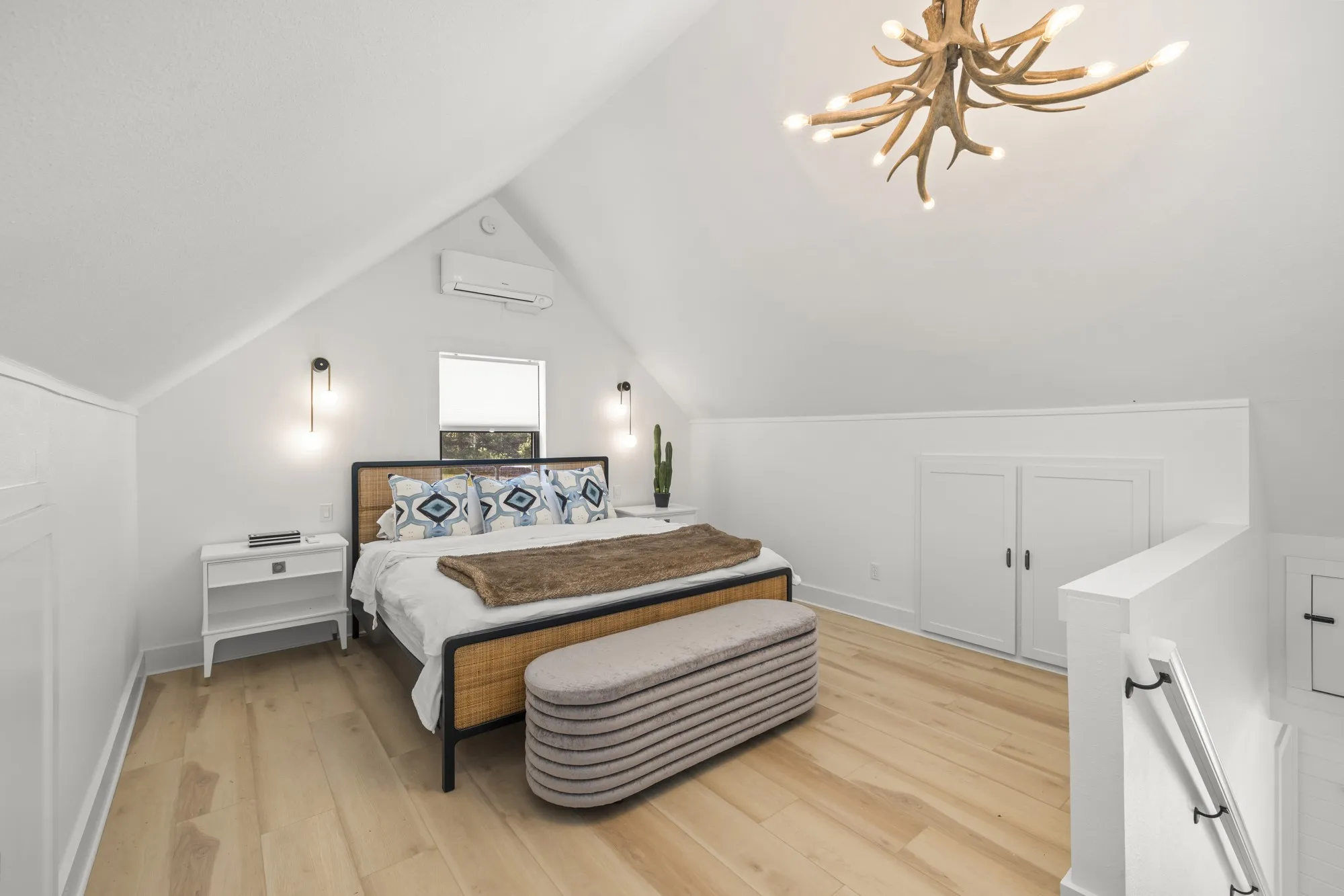 Bedroom featuring light wood-type flooring, vaulted ceiling, a chandelier, and a wall mounted AC