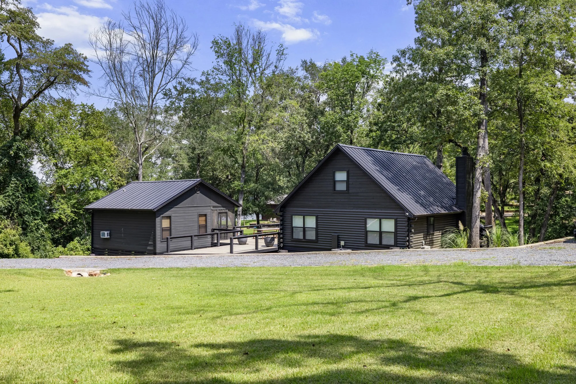 View of community featuring a lawn and view of wooded area