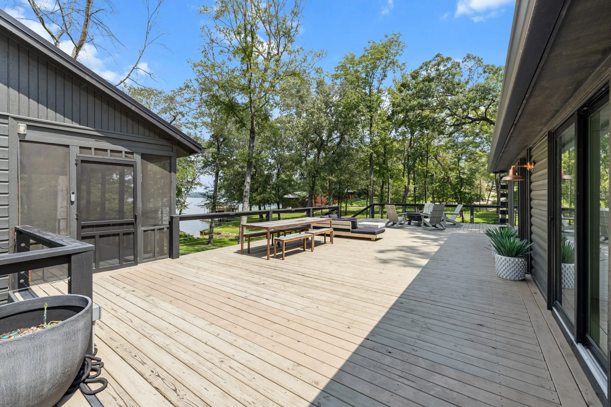 Wooden deck with a sunroom and outdoor dining area