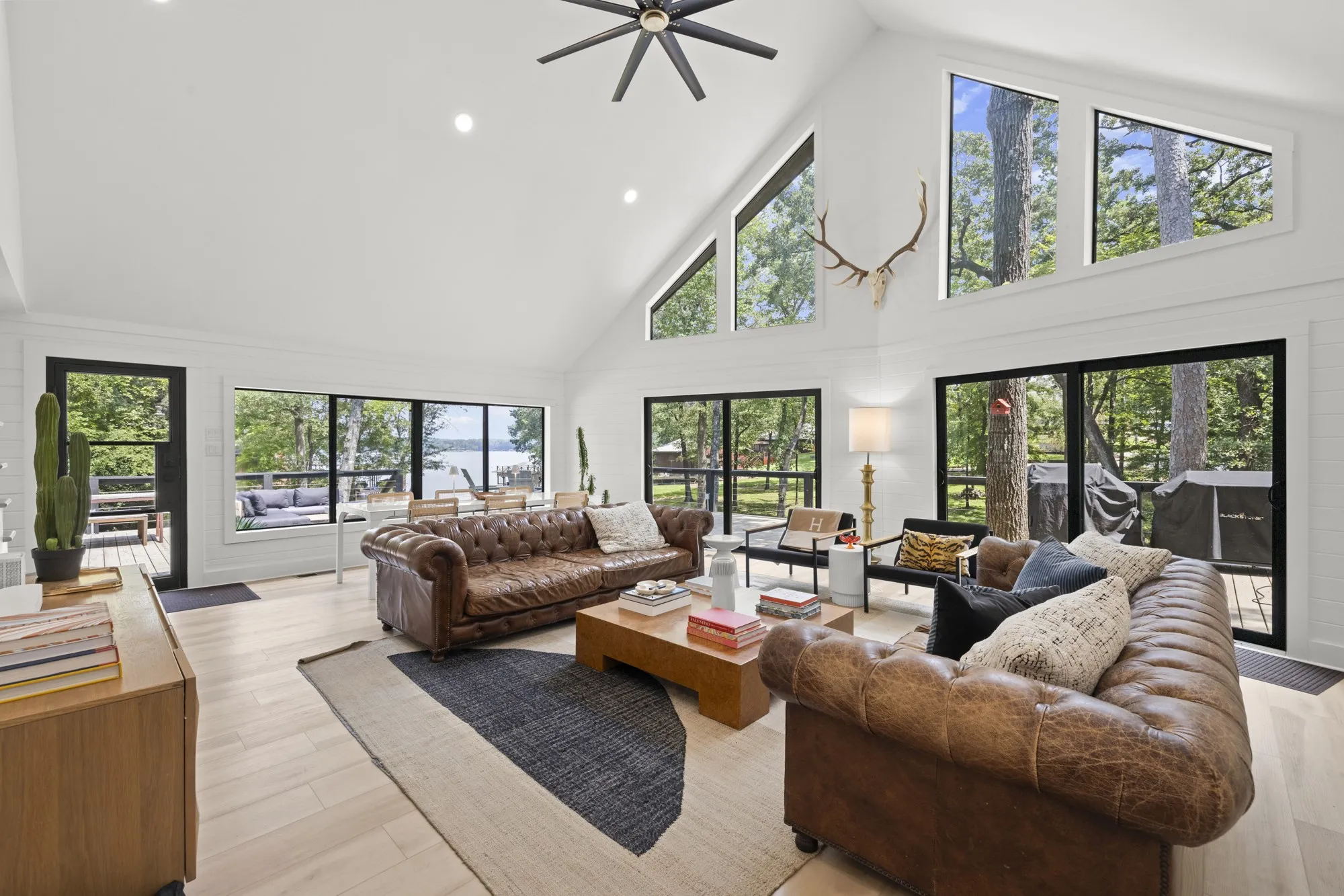 Living area with high vaulted ceiling, recessed lighting, healthy amount of natural light, a ceiling fan, and light wood-style flooring