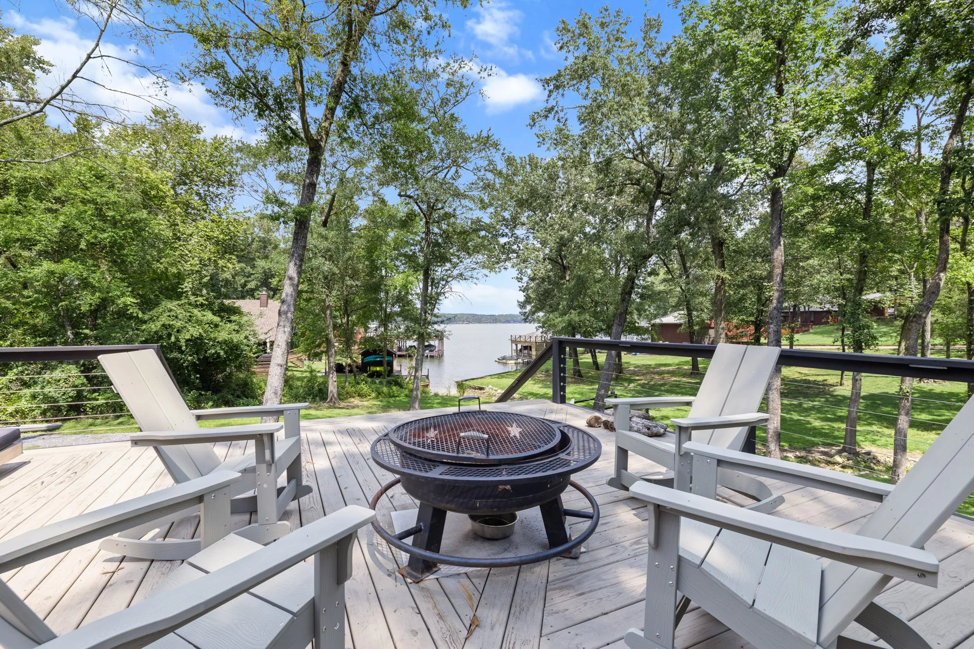 Wooden terrace featuring an outdoor fire pit and a water view