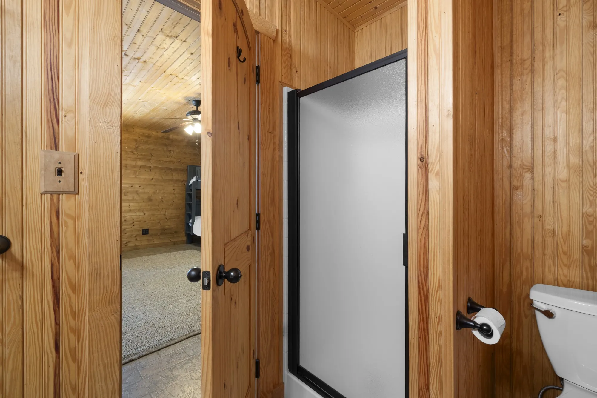 Full bath with wood walls and a stall shower