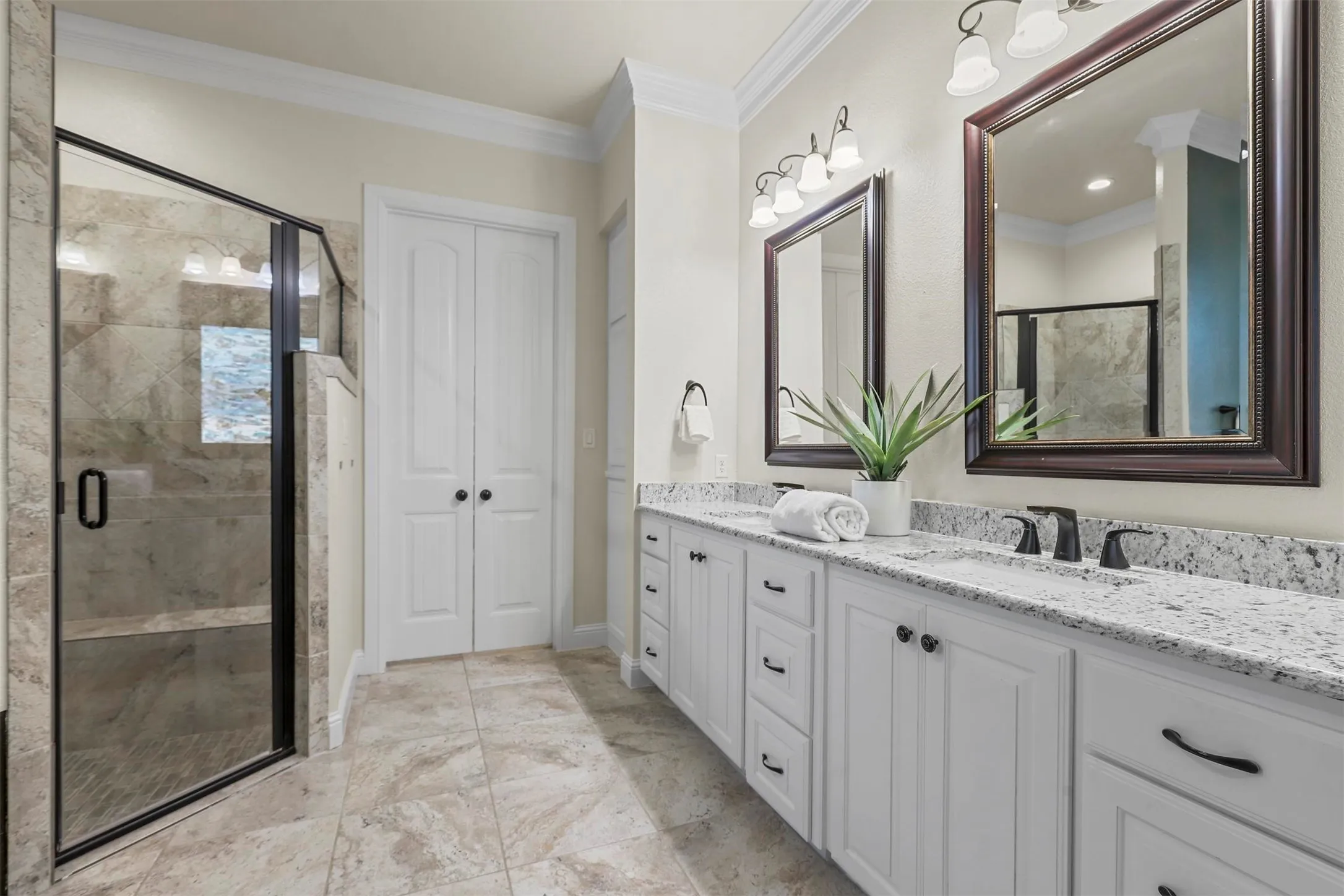 Dual vanities with white cabinetry, speckled countertops, and matte black fixtures