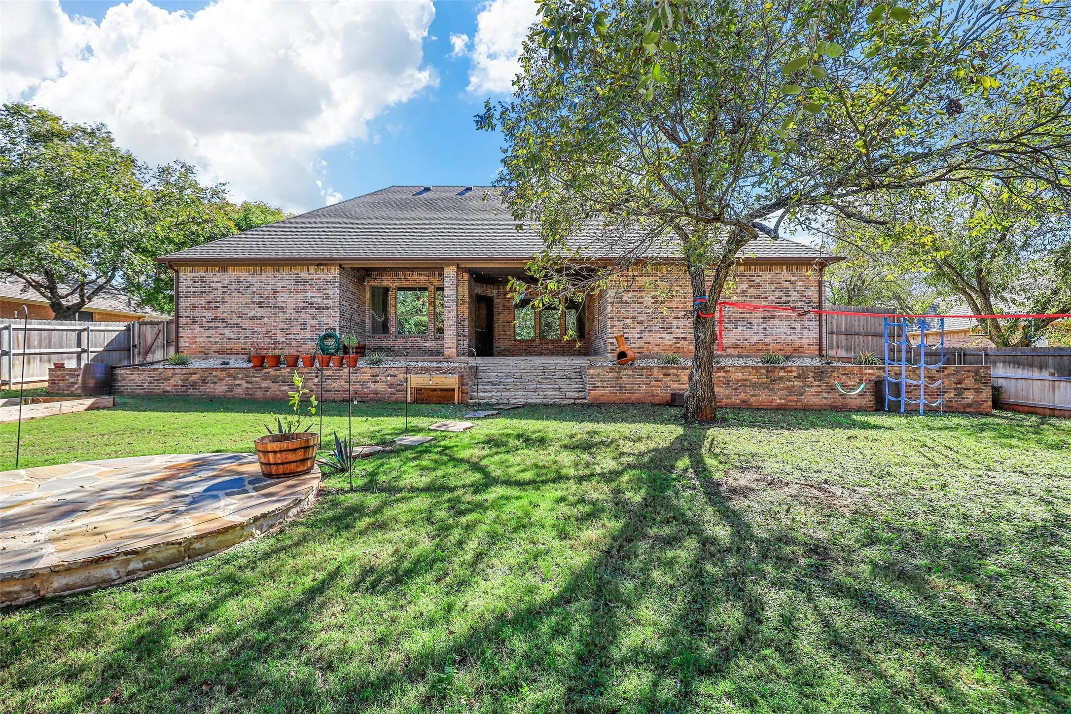 Brick exterior with a covered patio and multiple windows