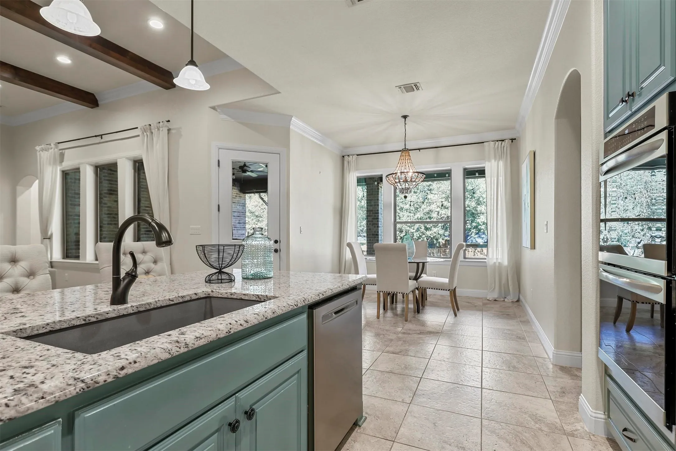 Kitchen island with granite countertop, integrated sink, and dishwasher