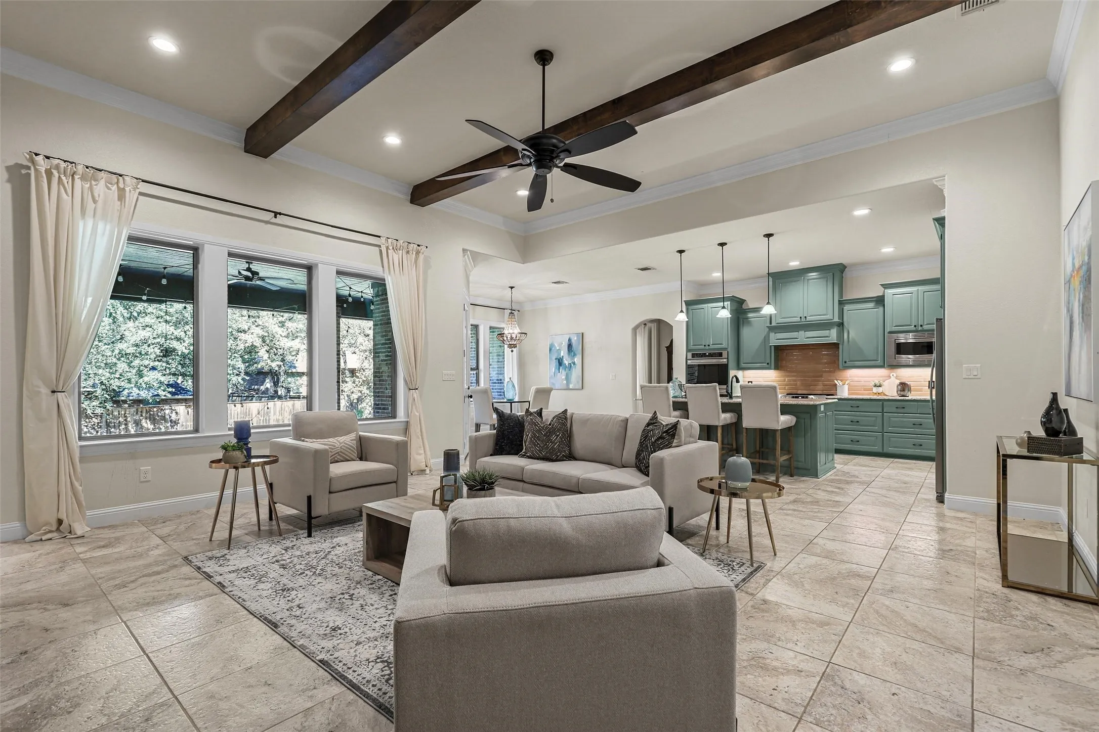 Open-concept living area featuring wood beams, recessed lighting, and a ceiling fan