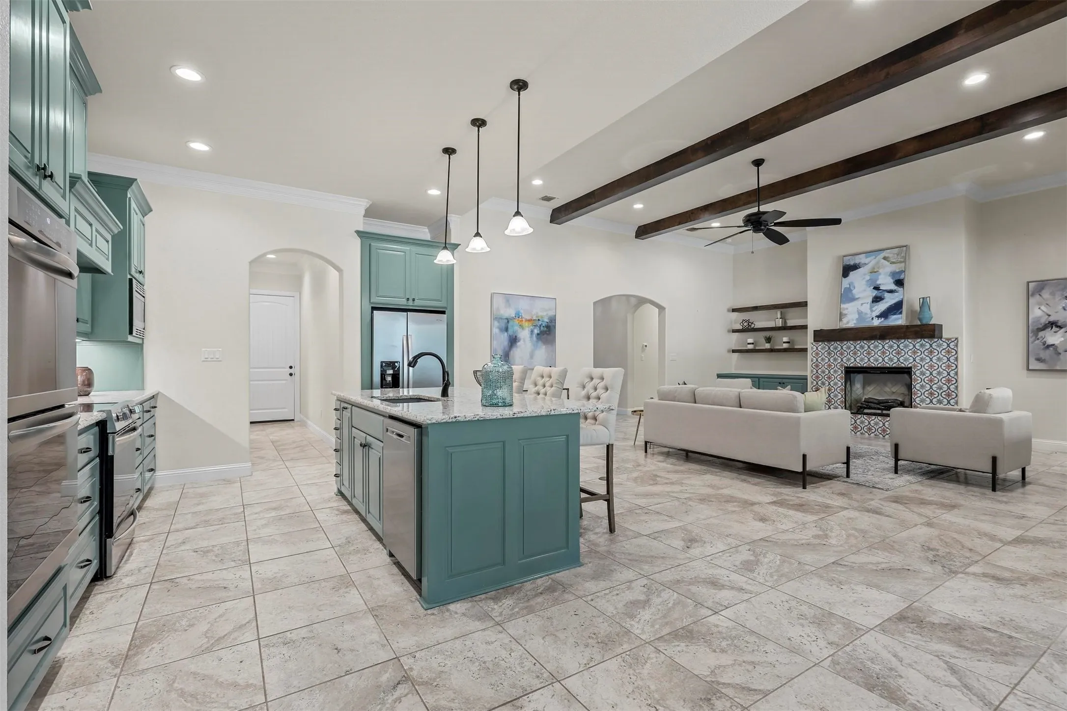 Open concept living space featuring a custom tile fireplace, exposed ceiling beams, a ceiling fan, and recessed lighting