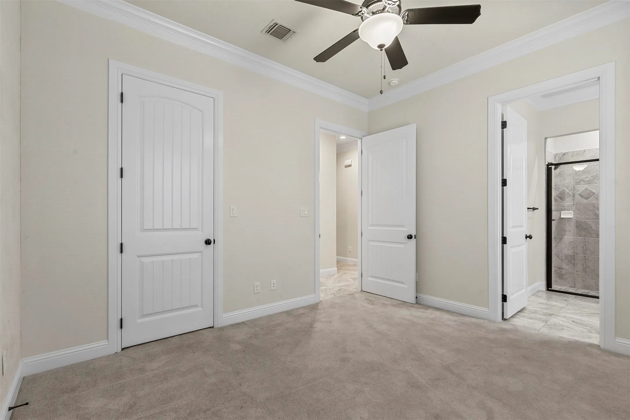 Carpeted room featuring white trim, a ceiling fan with light fixture, and paneled doors
