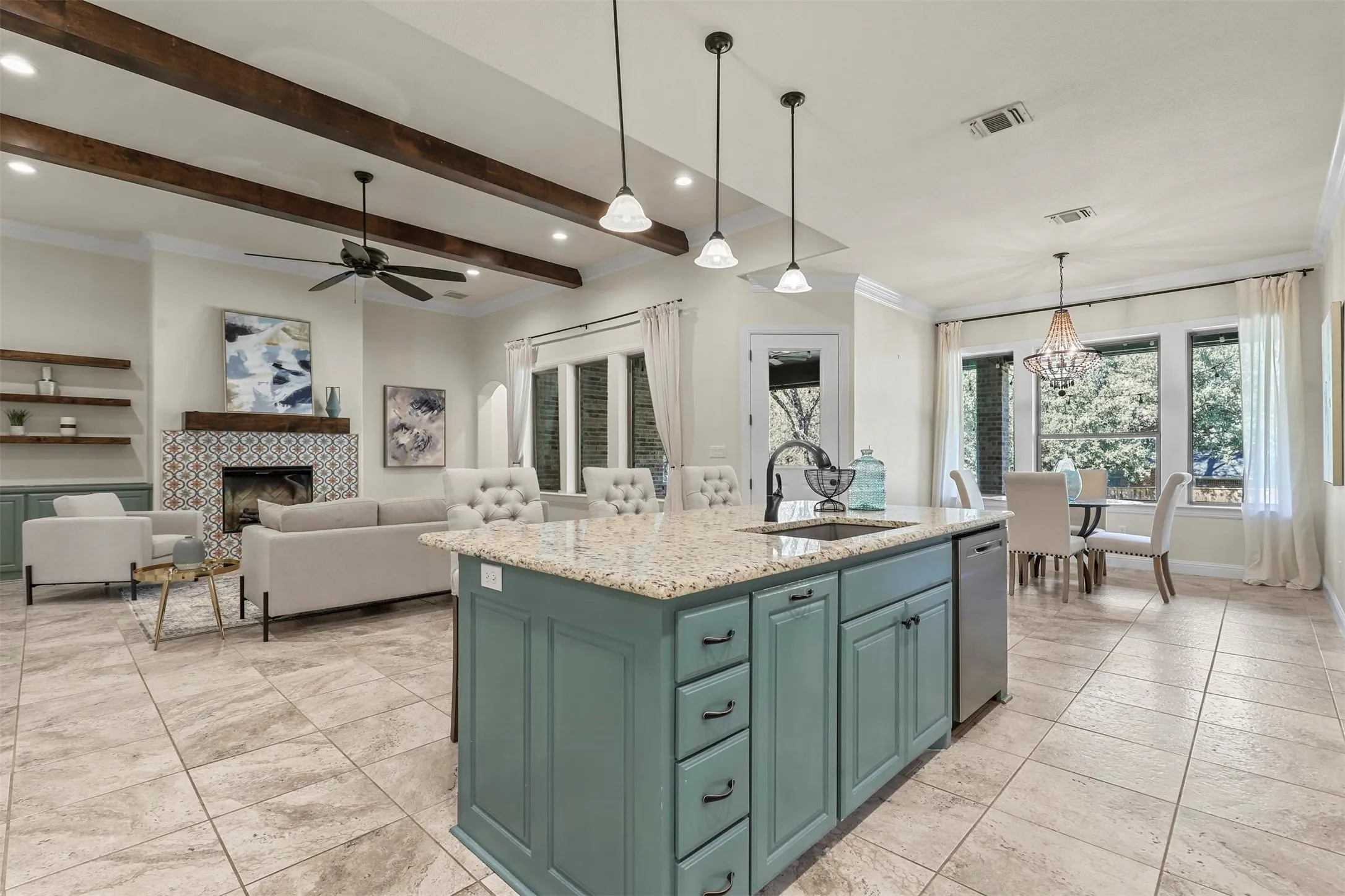 Spacious kitchen island with integrated sink, stainless steel dishwasher, and pendant lighting