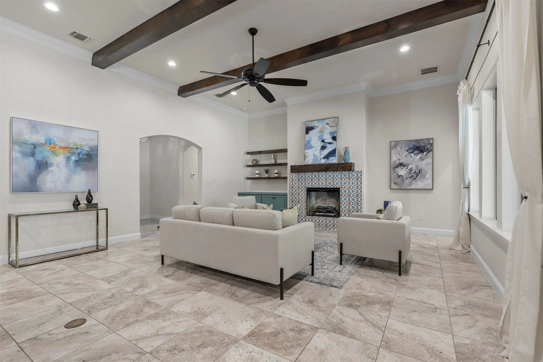 Vaulted ceilings with exposed wood beams, tile flooring, and a fireplace with decorative tile surround