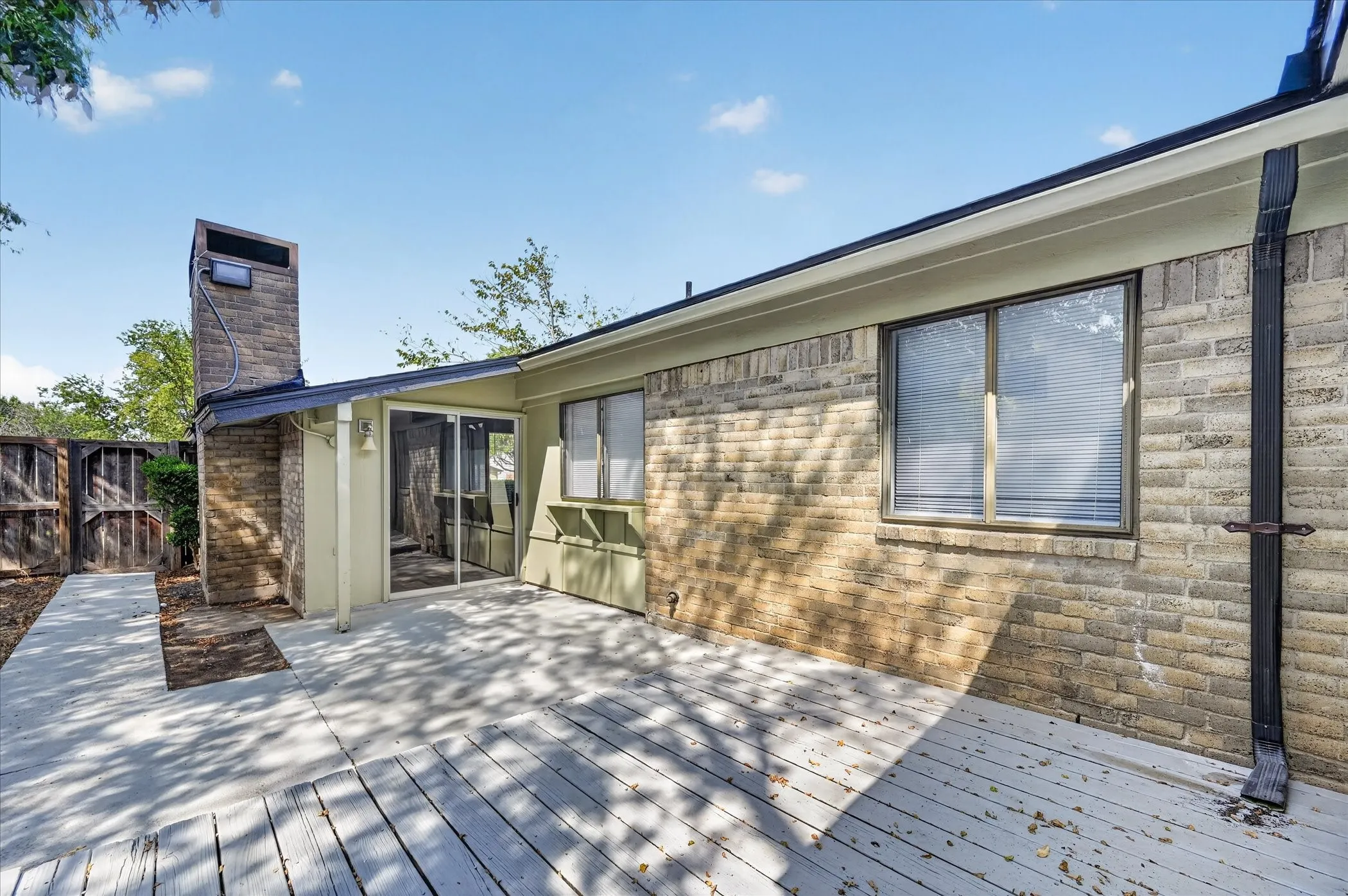 Expansive outdoor deck with a brick exterior and a privacy fence