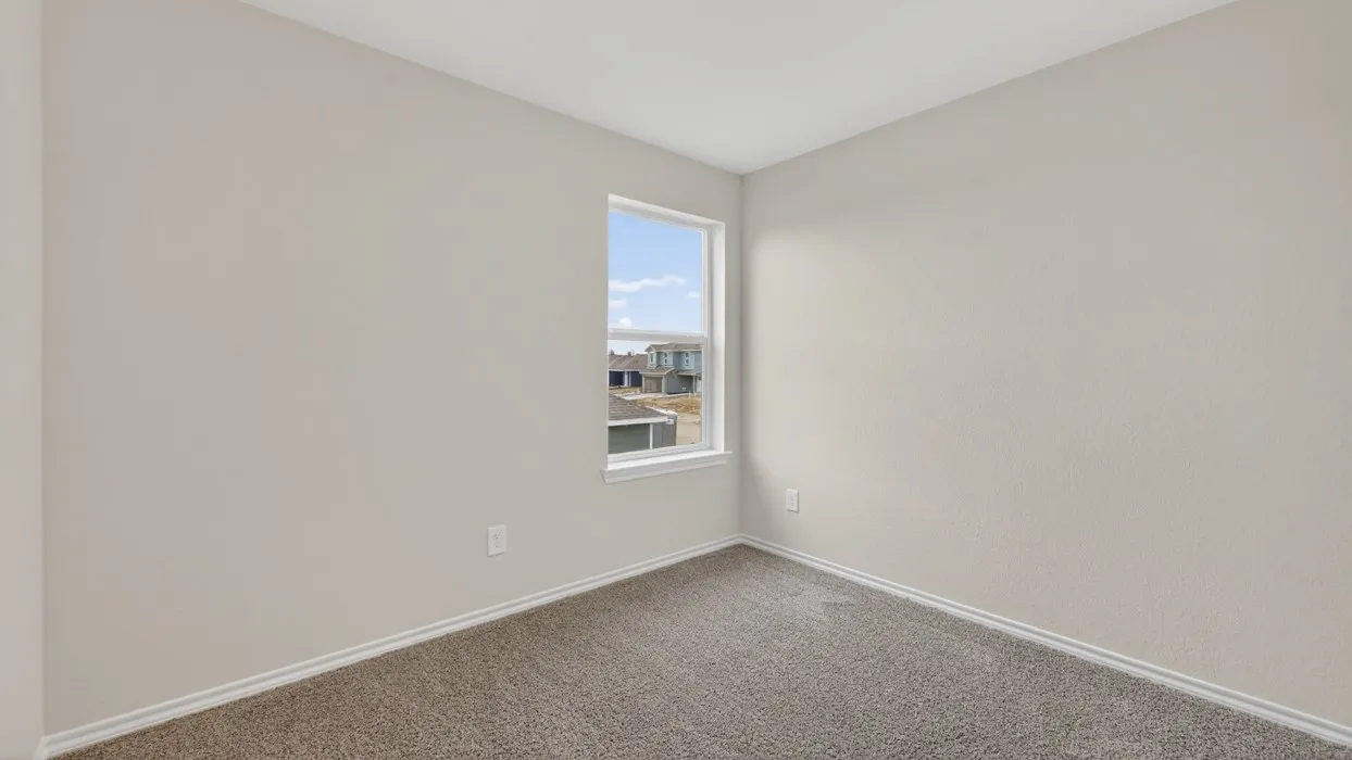 Compact room featuring a single window, neutral wall paint, and gray carpet flooring